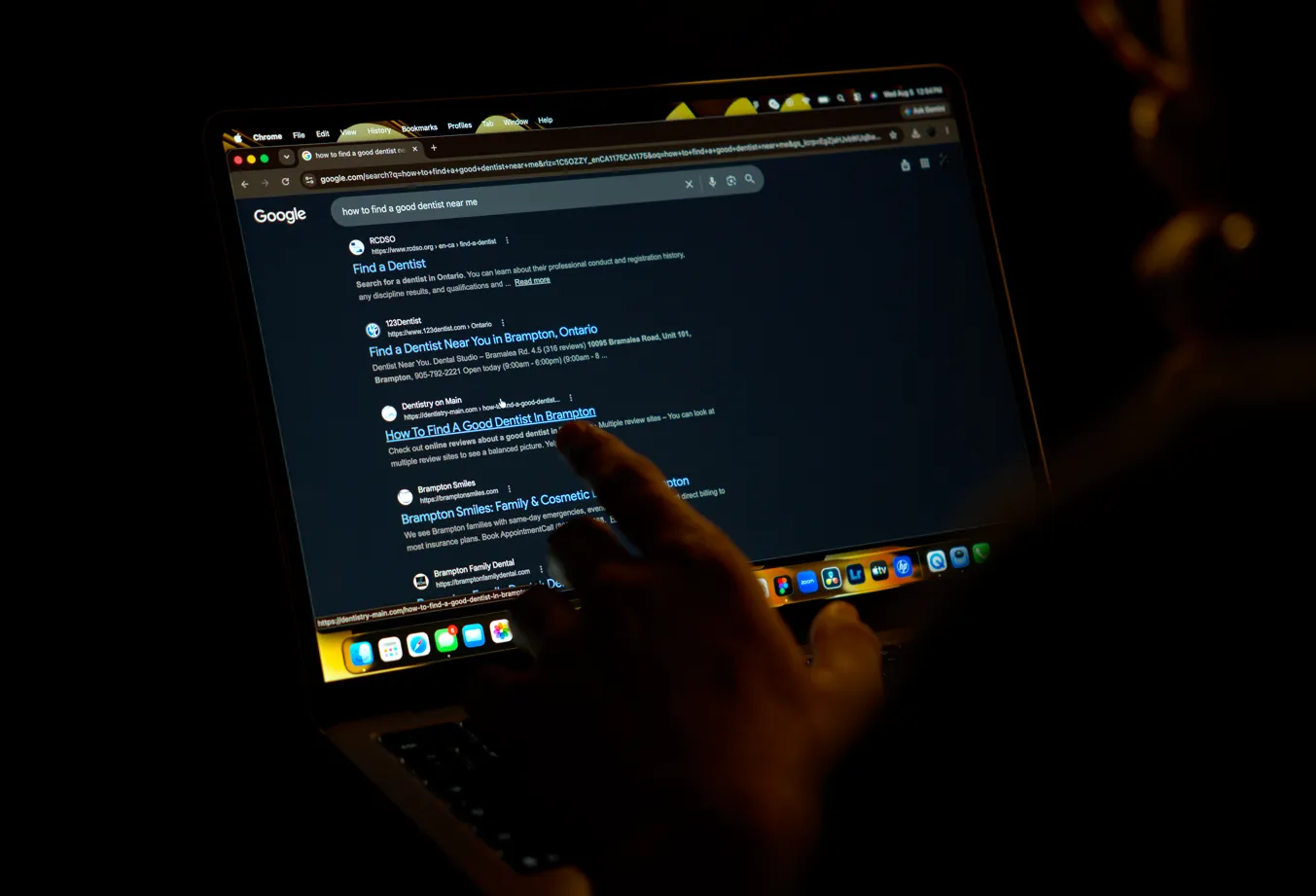 Man assessing a list of landing pages on his laptop following a google search inquiry.