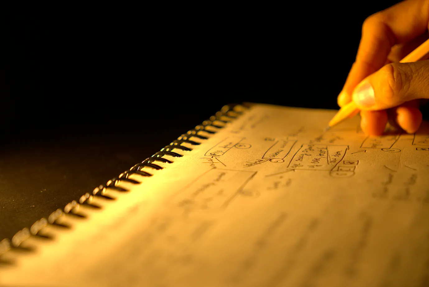 Man drafting ideas in his notebook.