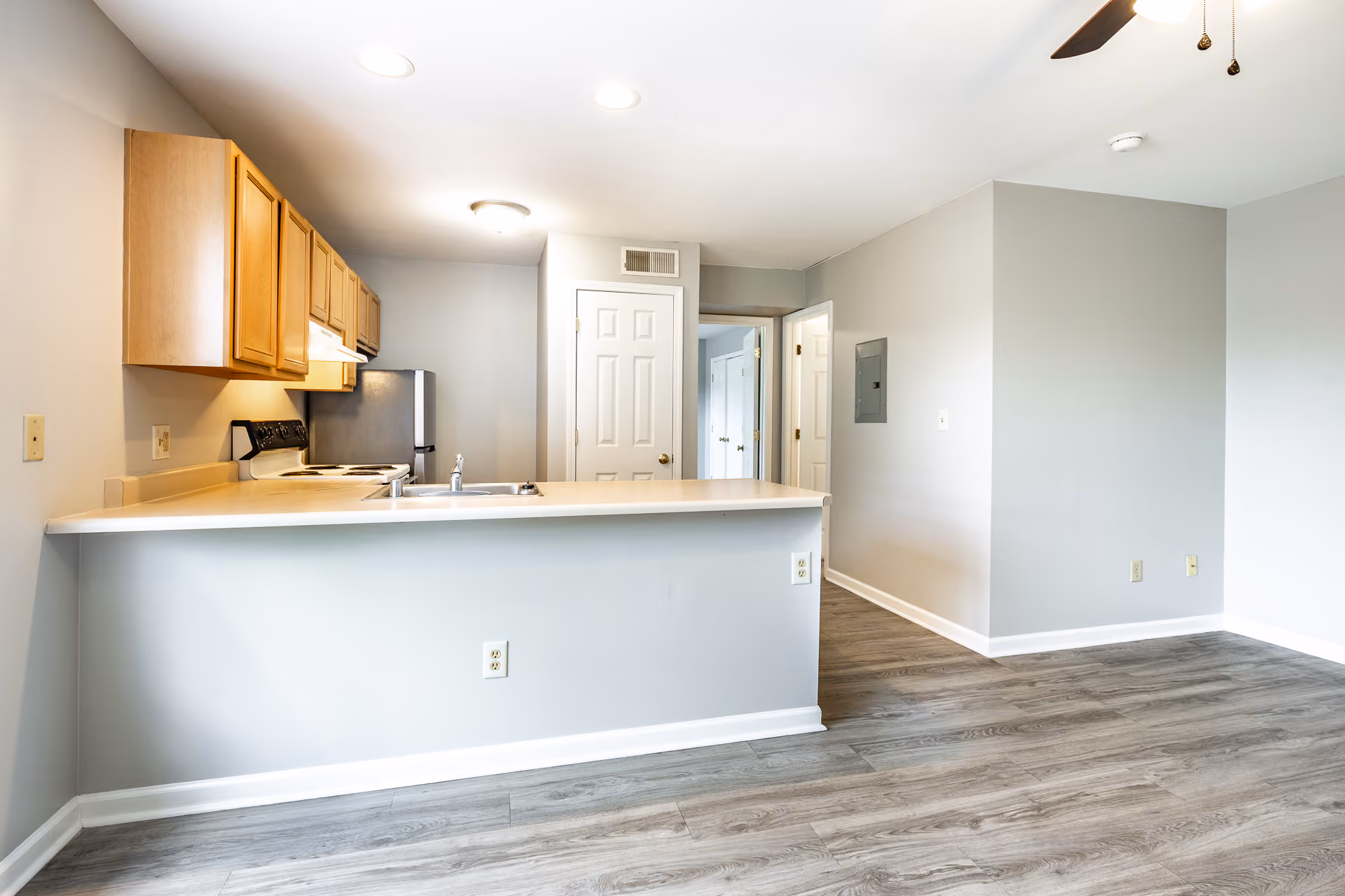 Kitchen with breakfast bar brown cabinets and stainless steel and white appliances