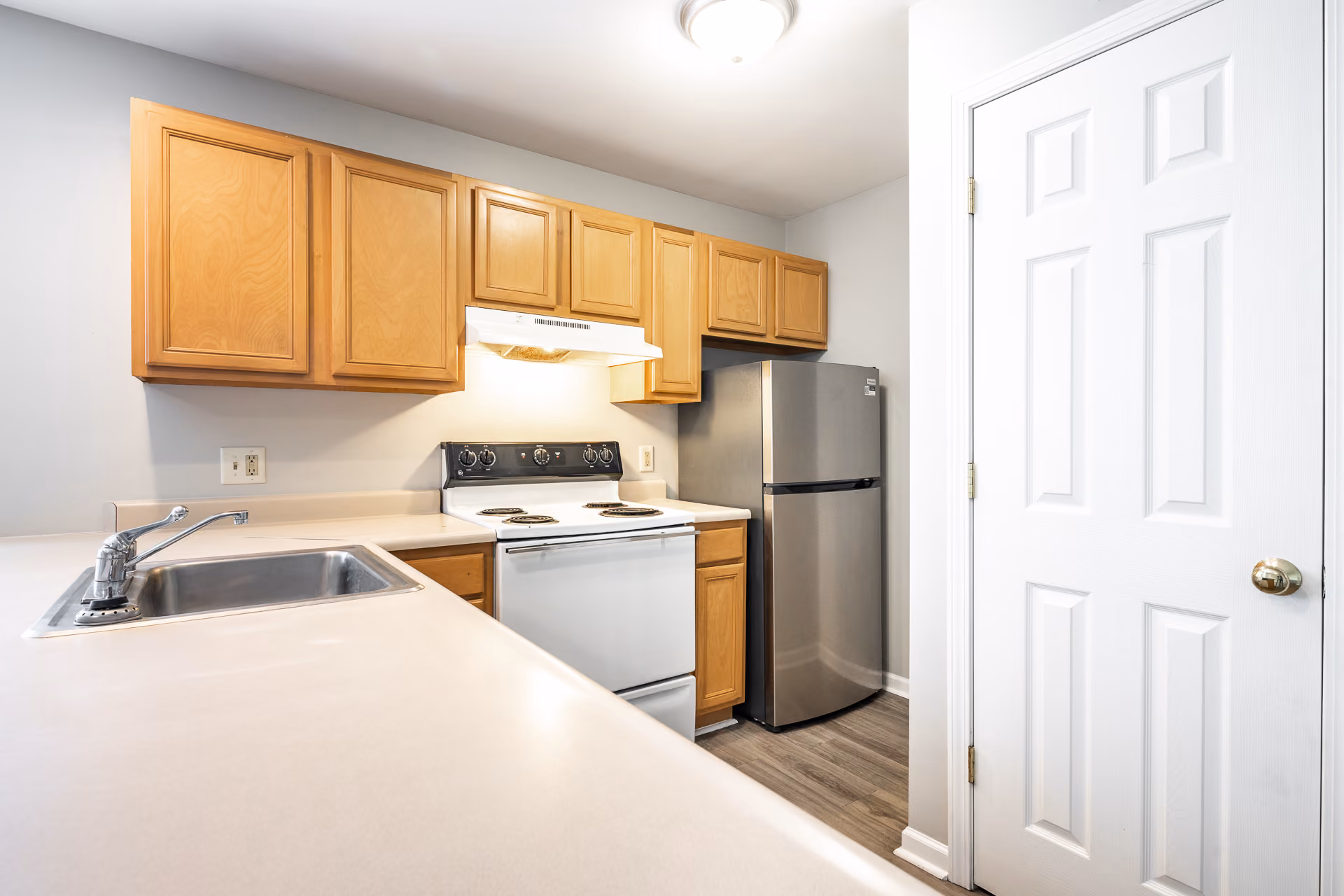 Kitchen with brown cabinets and stainless steel and white appliances