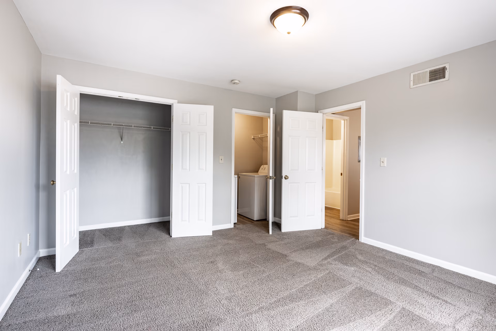 Unfurnished bedroom with carpet, laundry room, and closet