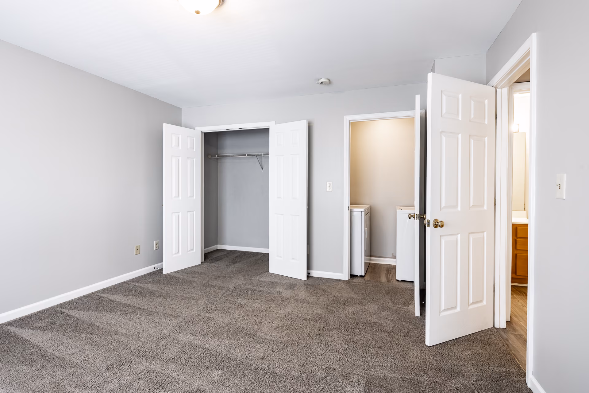 Unfurnished bedroom with carpet, laundry room, and closet