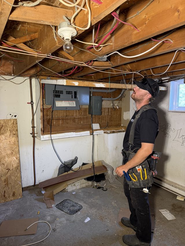 Électricien inspectant une installation pour une mise aux normes électriques