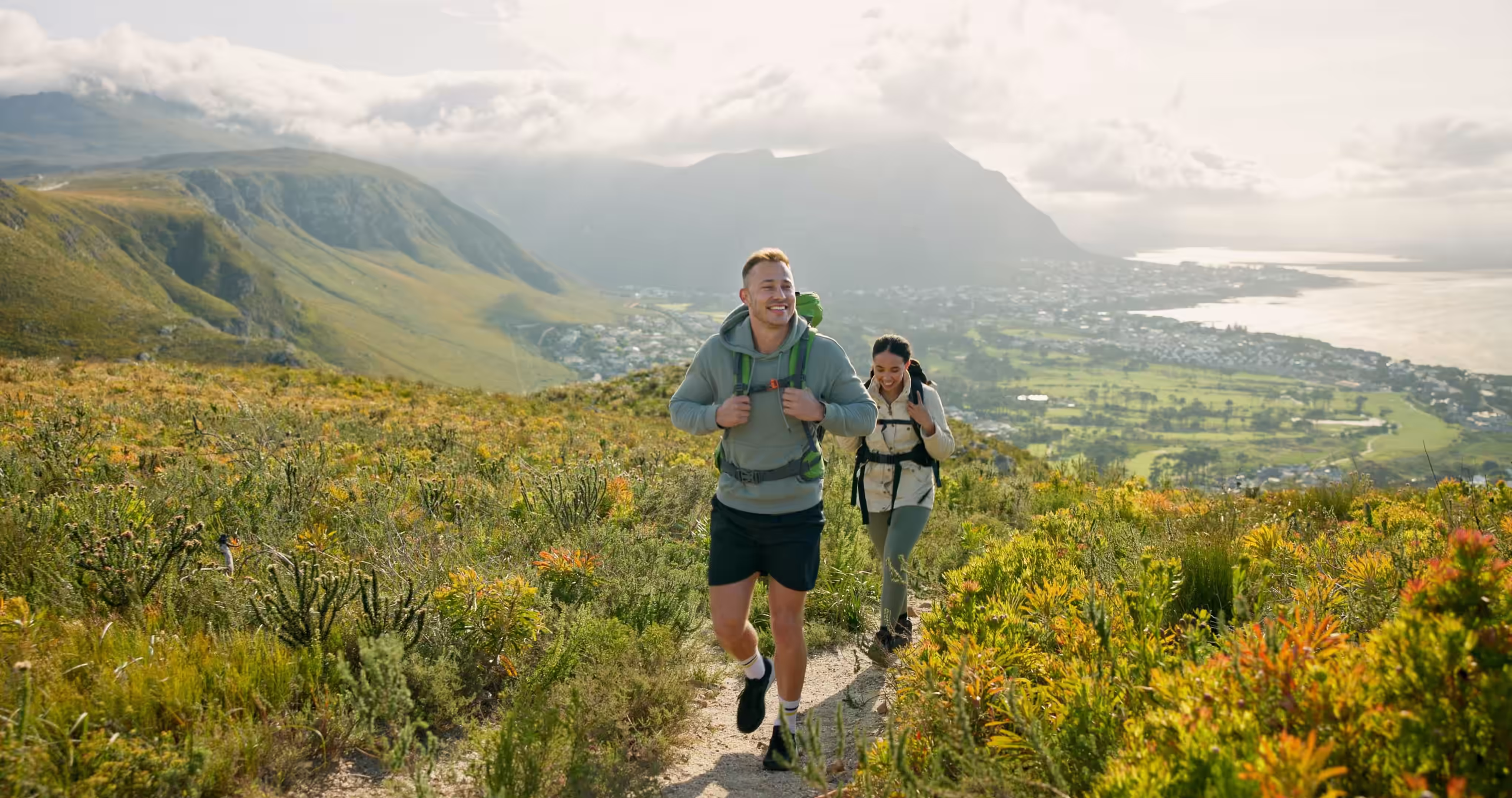 Young couple hiking on trail surrounded by cactuses and beautiful views