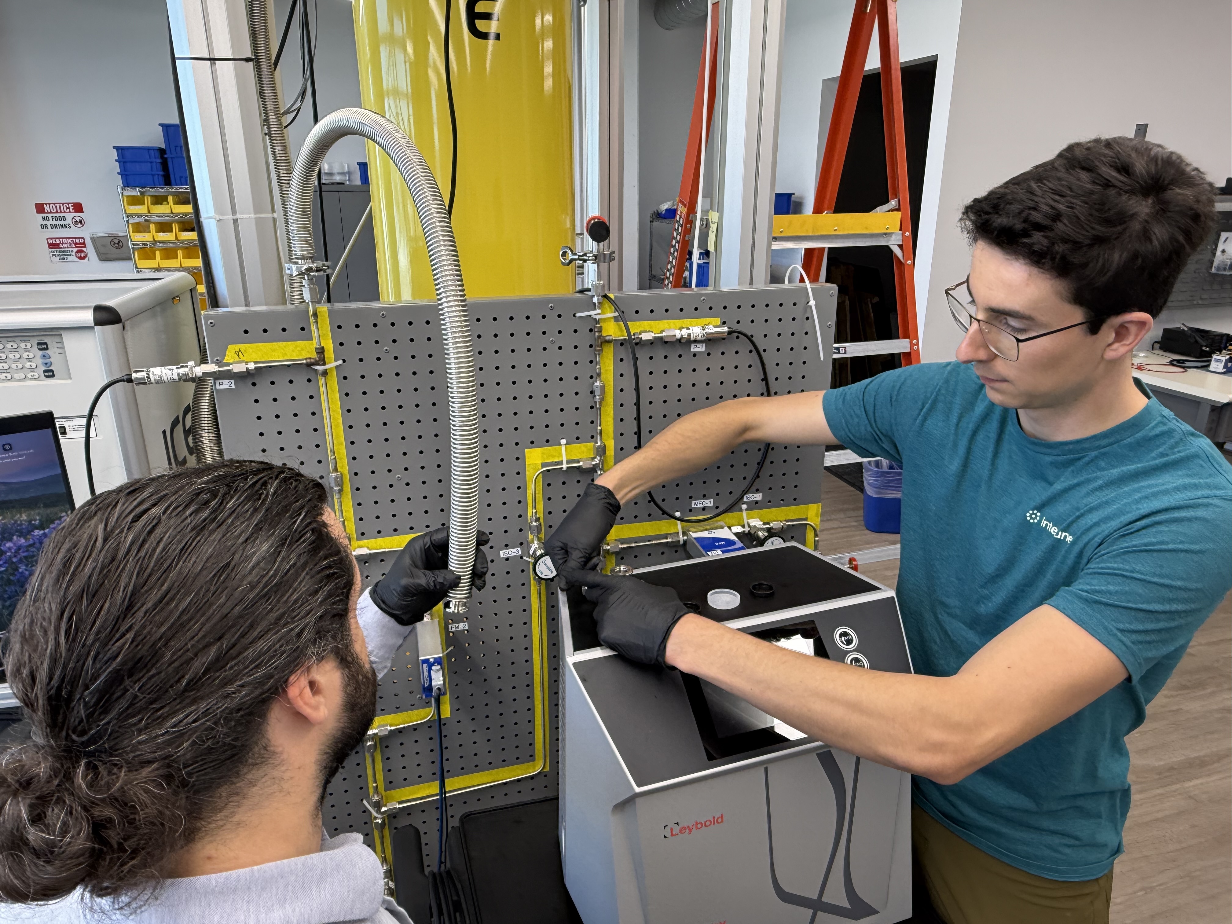 Mechanical Engineer Sam Heyd and Chemical Engineer Brenden Pelkie install a helium leak detector at Interlune’s Cryogenic Lab at the company’s Seattle headquarters