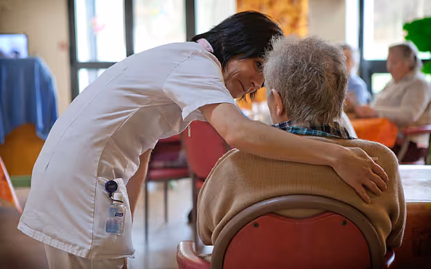 A healthcare professional providing compassionate care and support to an older adult in a long-term care setting