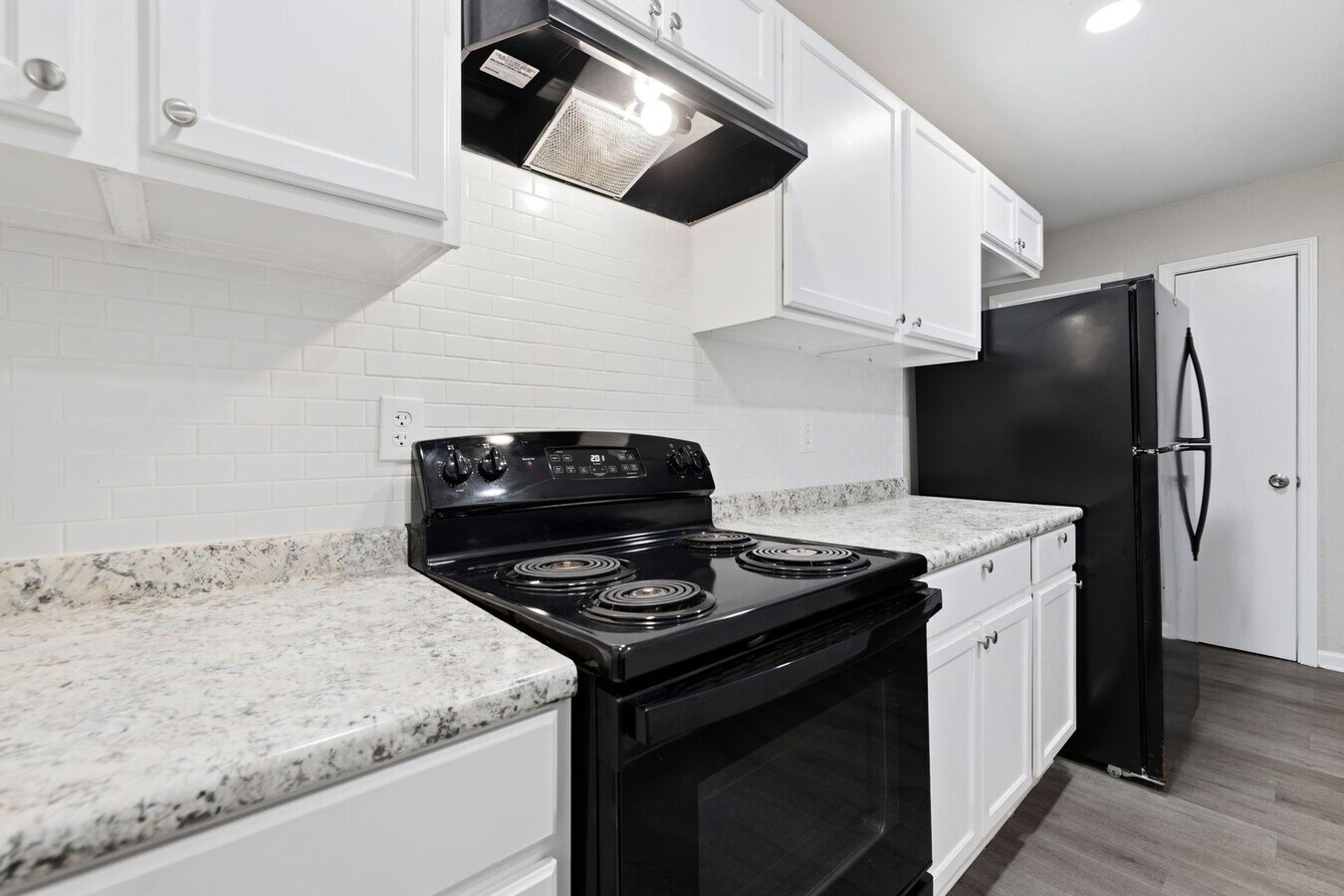 Renovated kitchen with granite countertops and subway tile