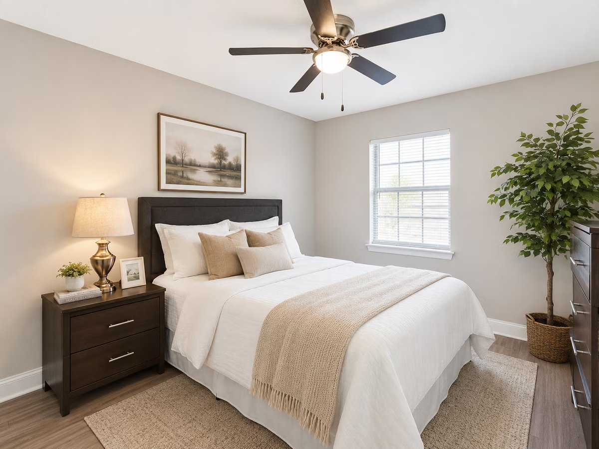 Staged bedroom with dark headboard and ceiling fan