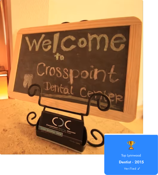 Chalkboard sign reading 'Welcome to Crosspoint Dental Center' on a black ornate stand.