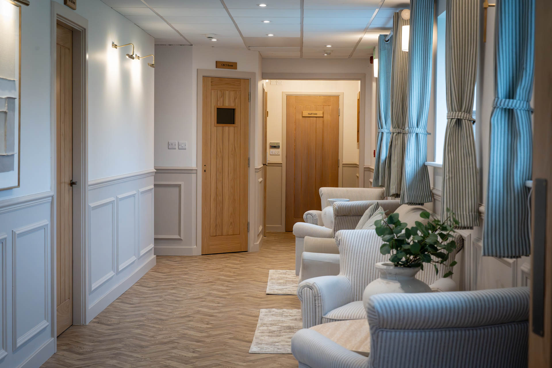 Bright waiting area with armchairs along the clinic corridor
