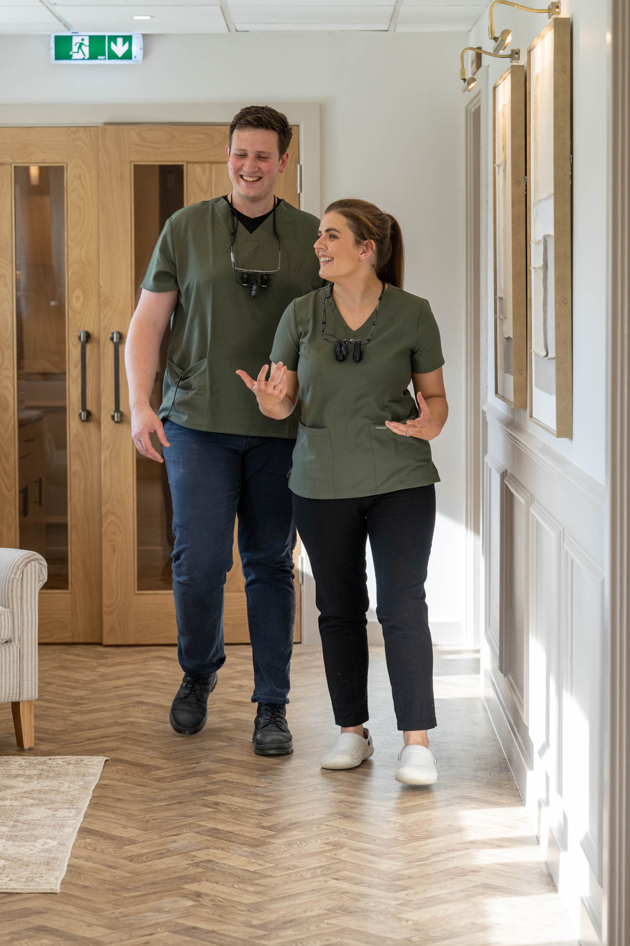 Two members of the dental team walking along the clinic corridor