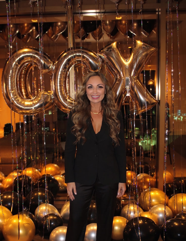 Cat Gagliardo standing infront of CCX balloons