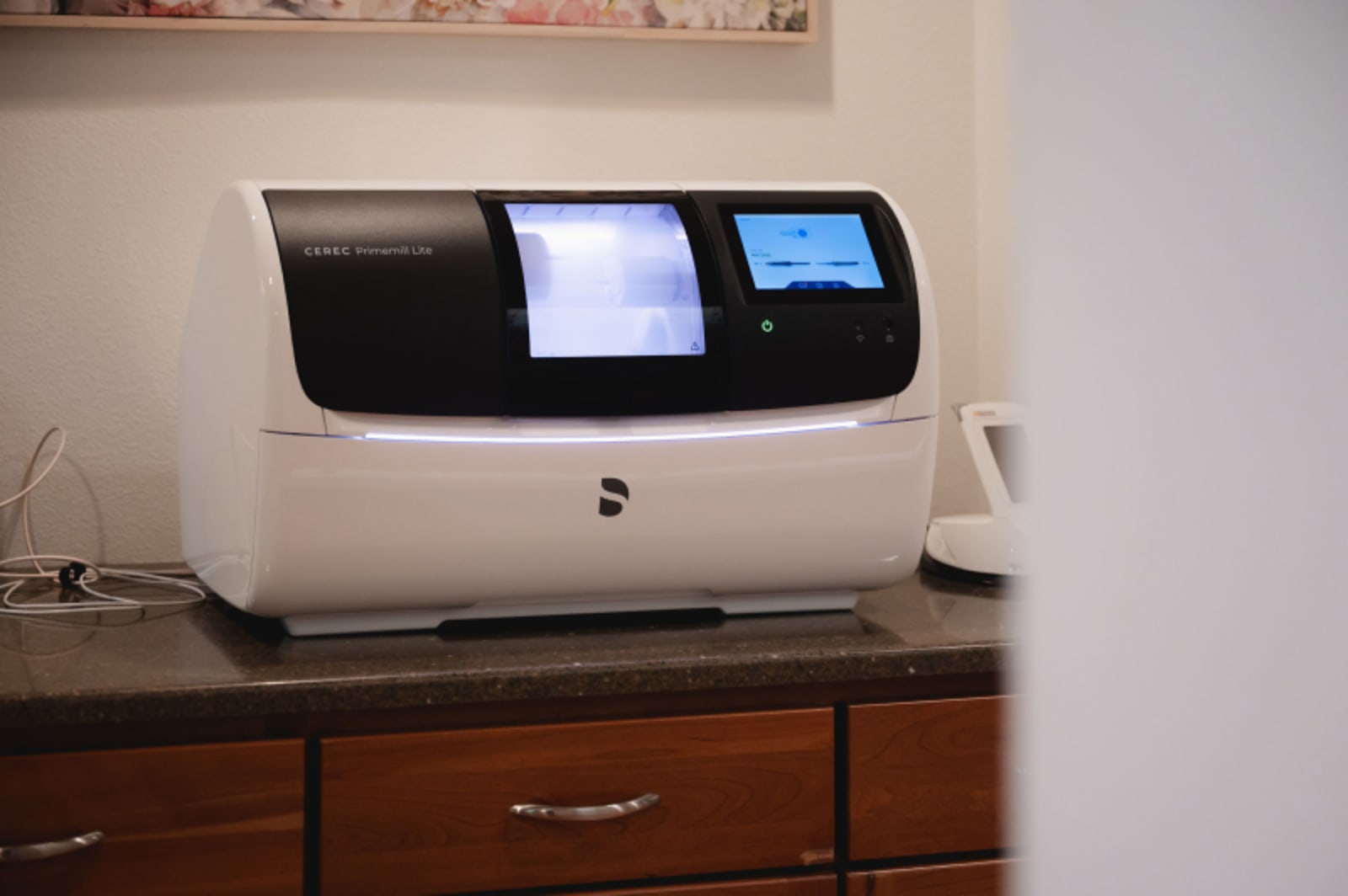Dental equipment display showing digital imaging/scanning device on cabinet