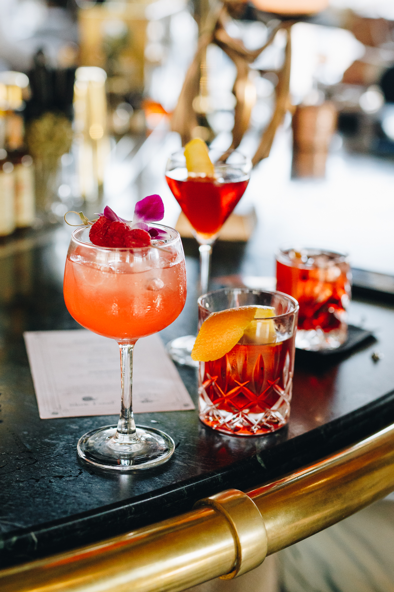 Craft cocktail beside a printed bar menu