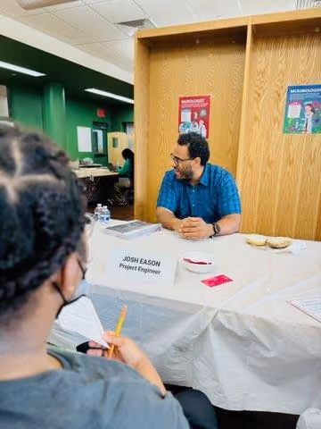 Project engineer Josh Eason speaking with a student at career fair