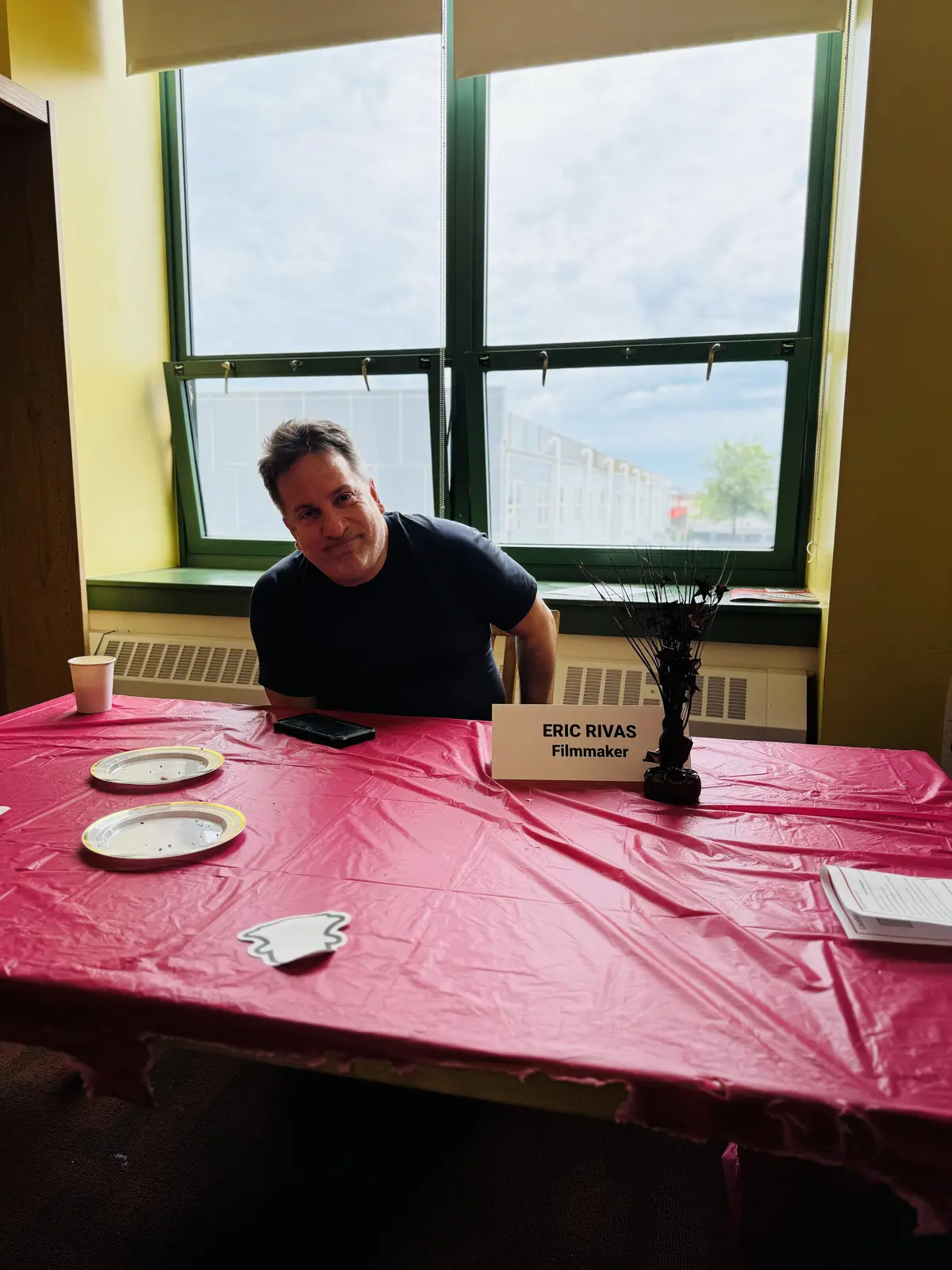Filmmaker Eric Rivas seated at a table during a school event