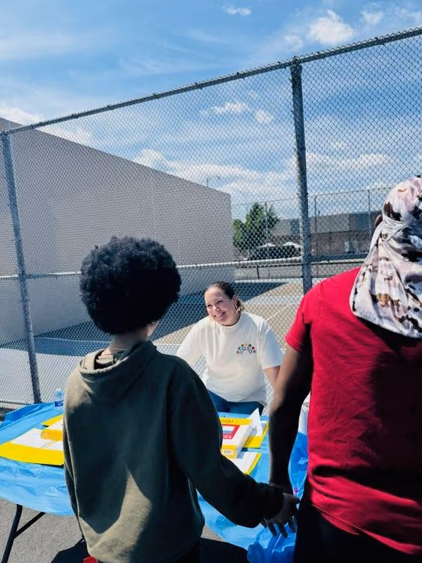 Staff member smiling at students during outdoor school event