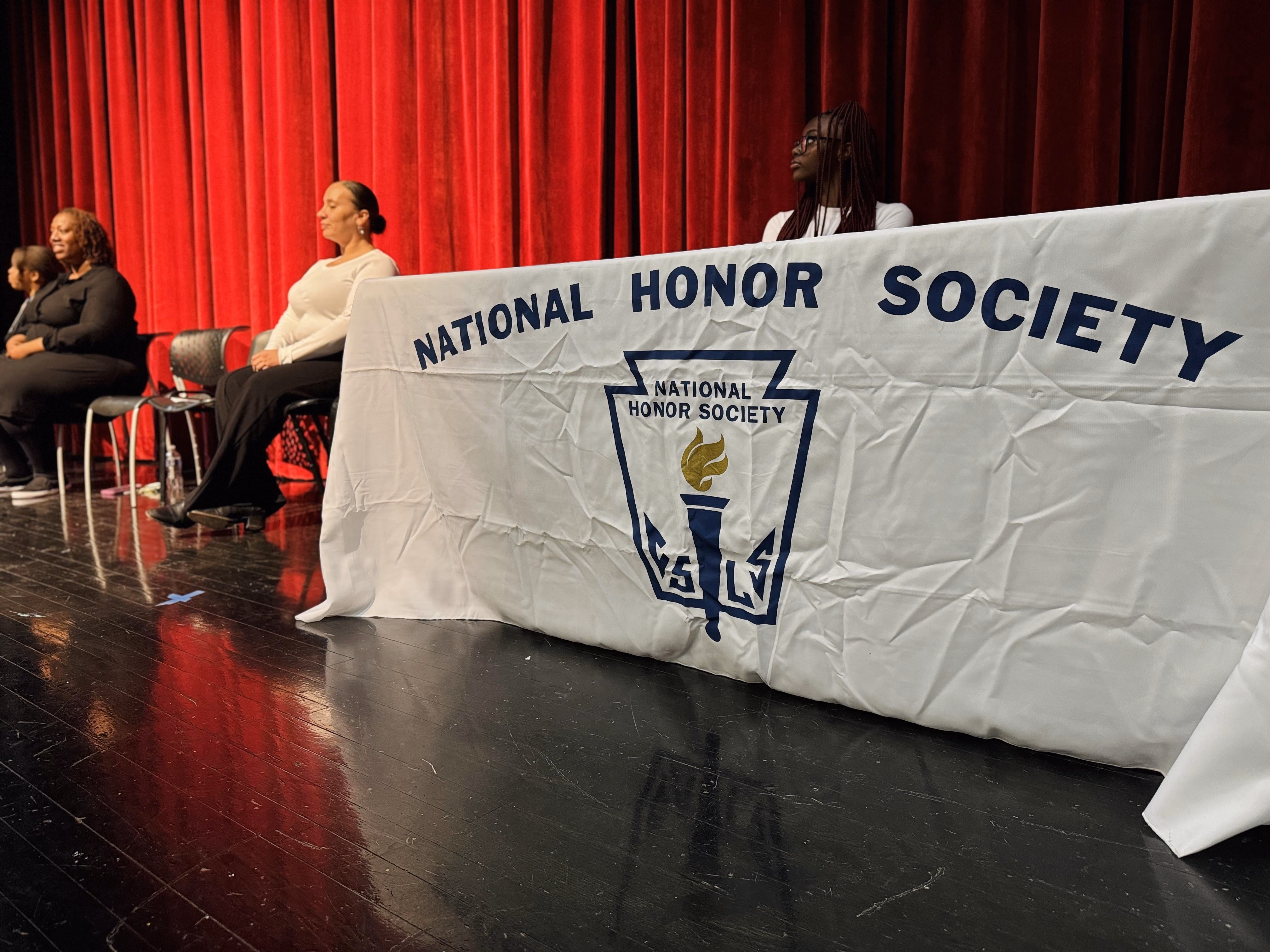 Students seated on stage at National Honor Society induction ceremony