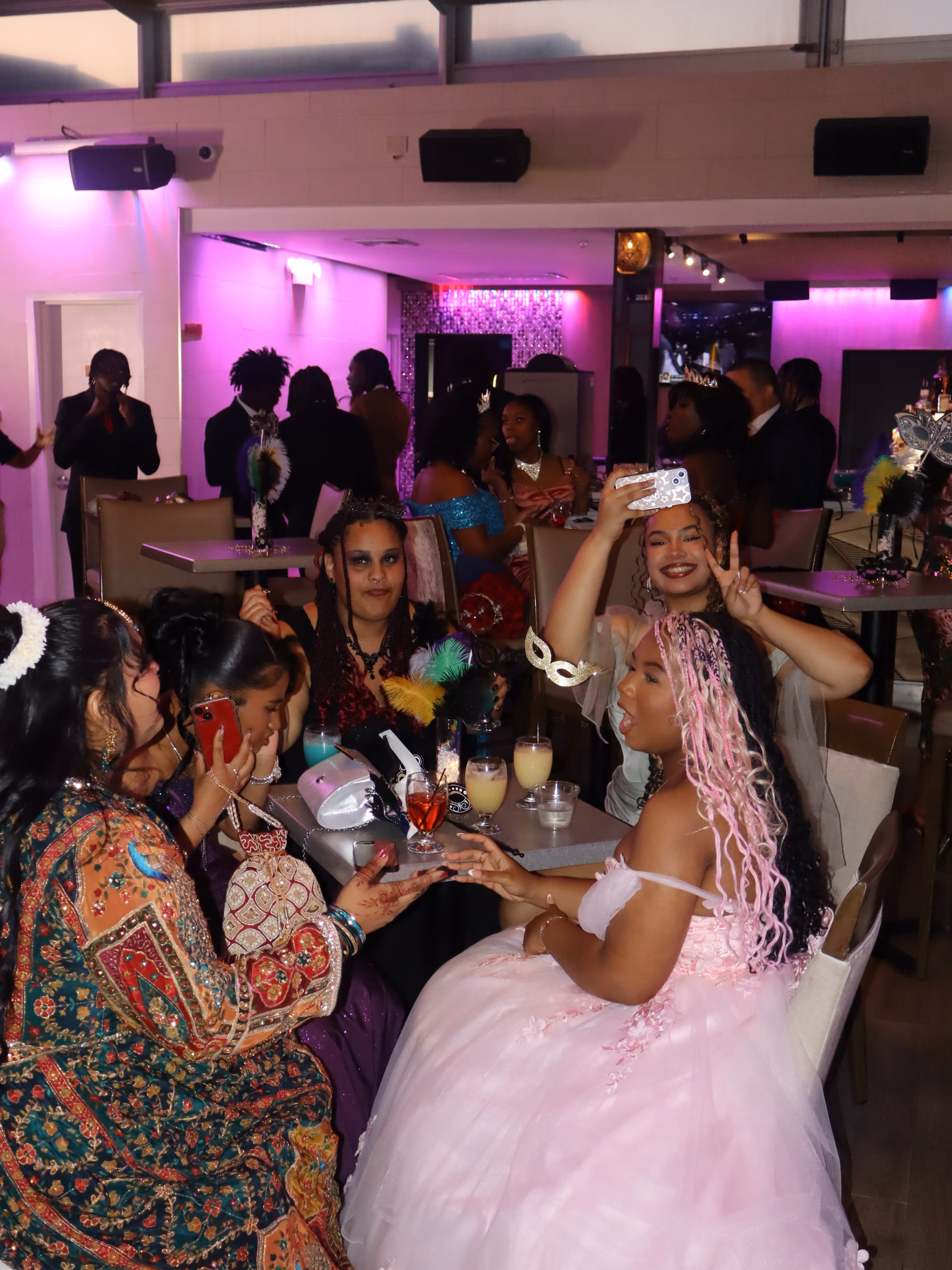 Students in formal attire celebrate together at a school prom event