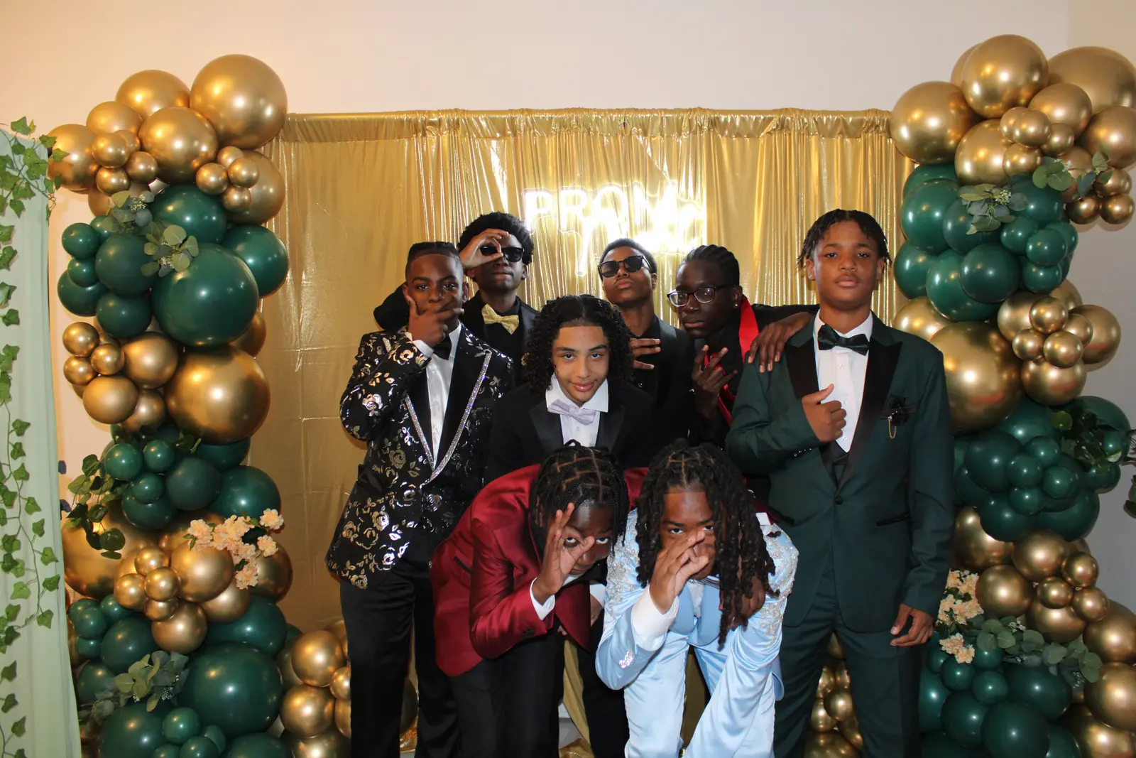 Students in formal attire posing at prom photo booth