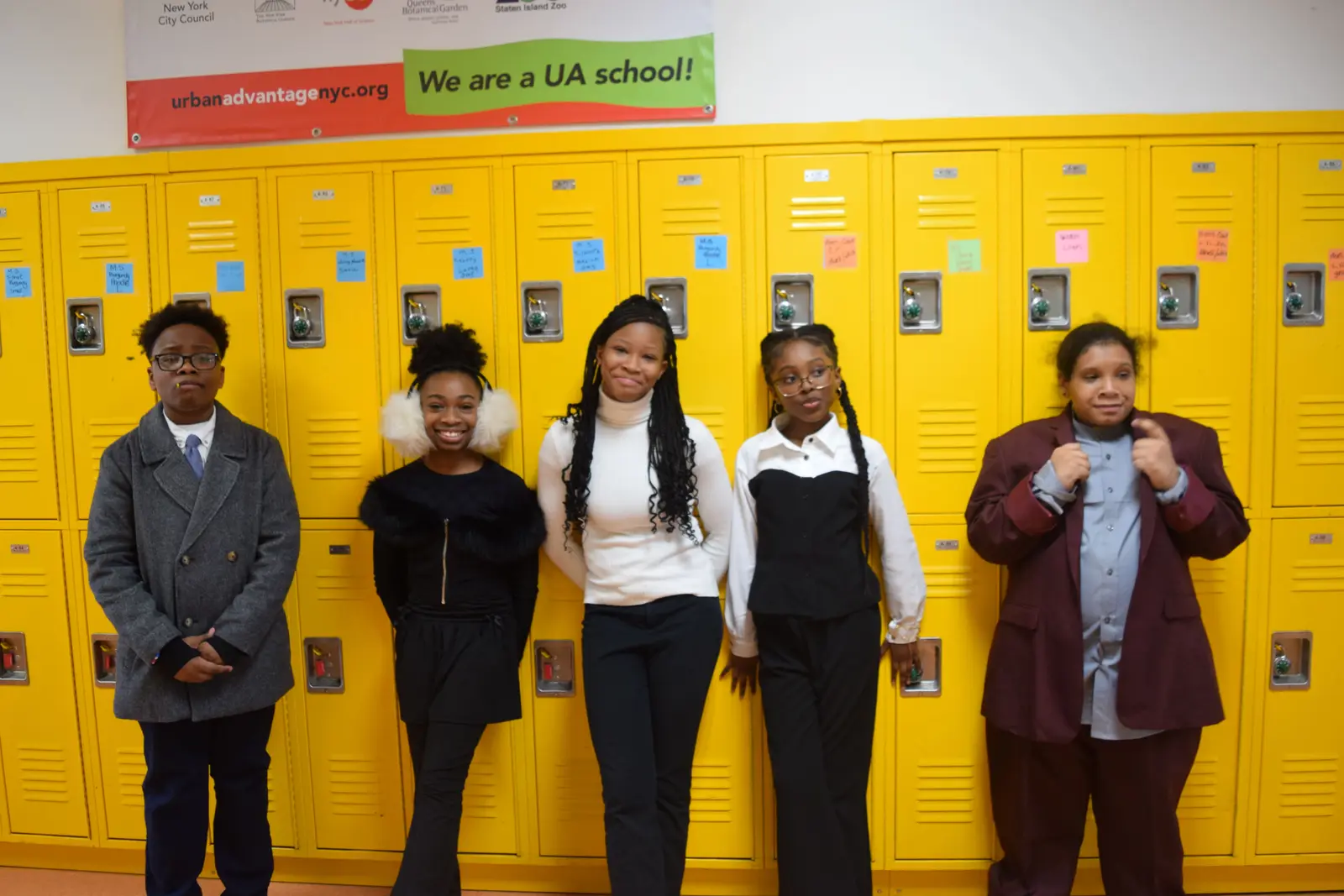 Five students posing in front of yellow school lockers