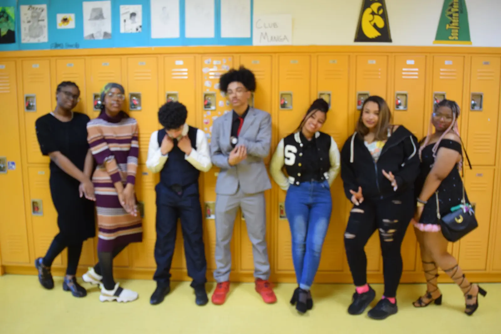 Seven students posing together in front of school lockers