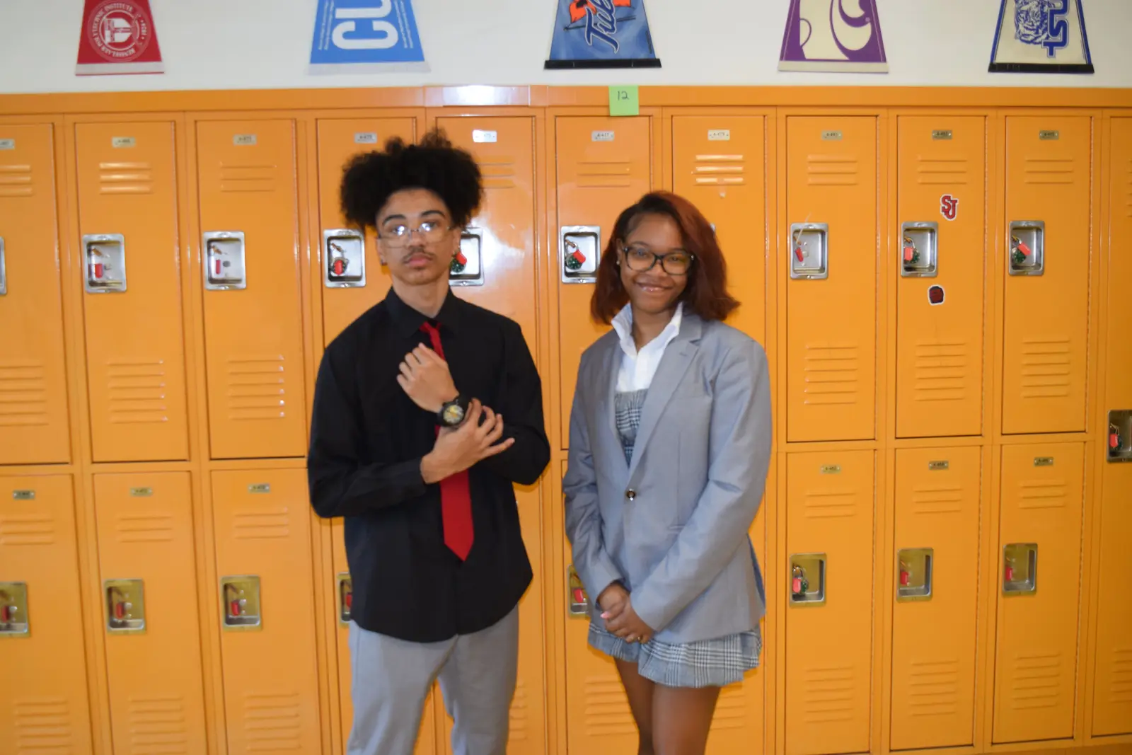 Two dressed-up students posing in front of school lockers