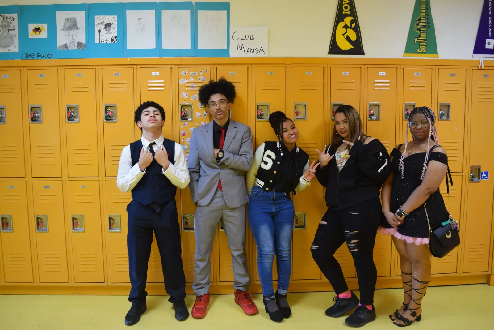 Five students posing in front of yellow school lockers