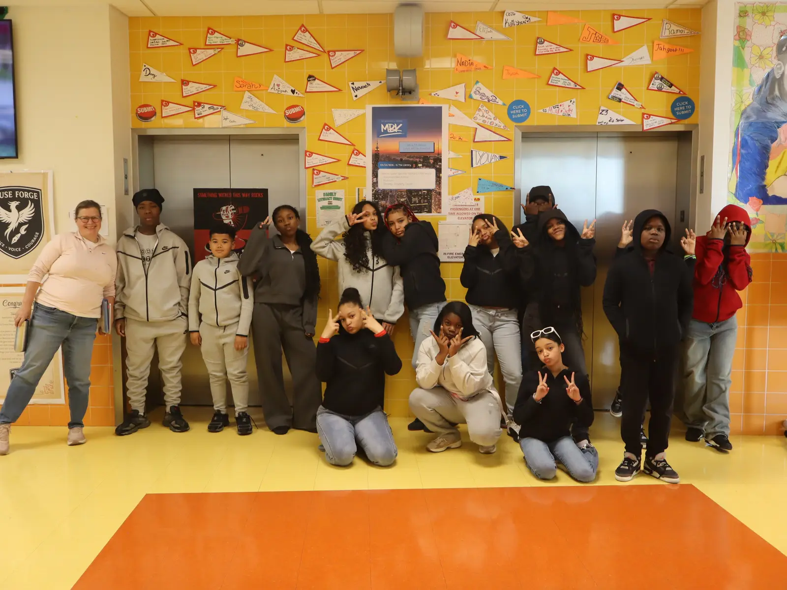 Students and teacher posing together in decorated school hallway