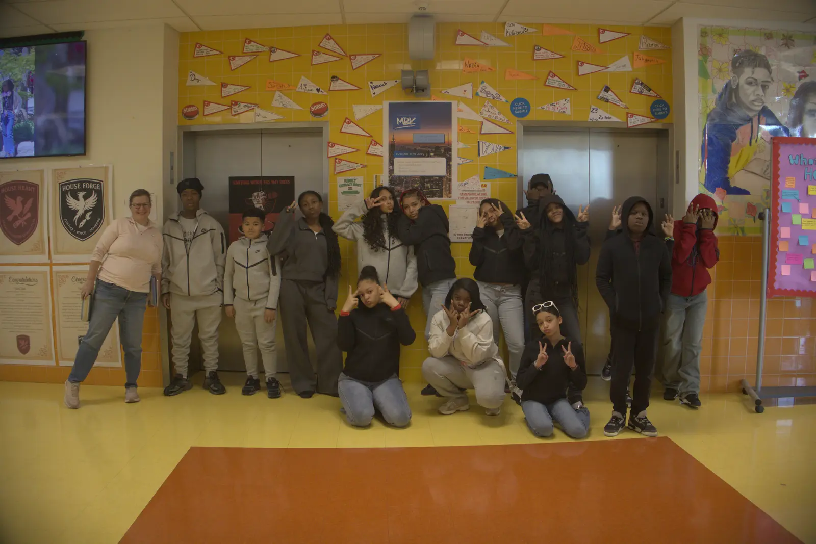 Students and teacher posing together in school hallway