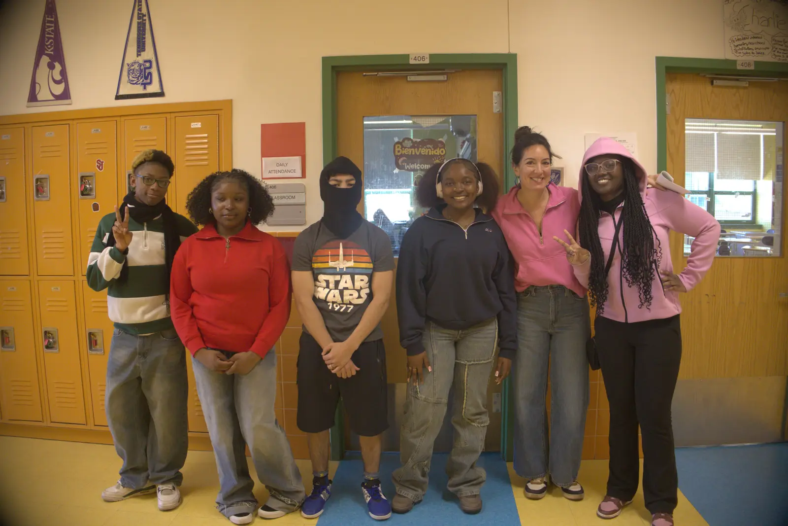 Teacher and five students posing together in a school hallway