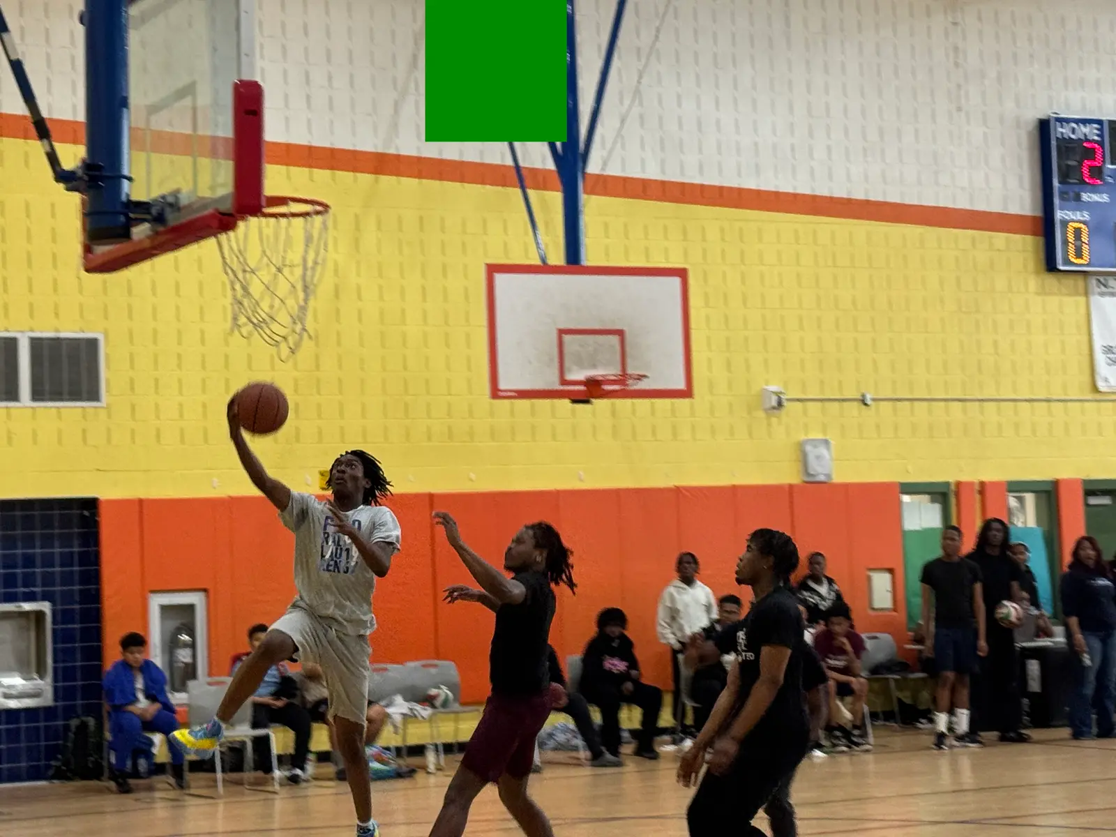 Student athlete goes up for a layup during indoor basketball game
