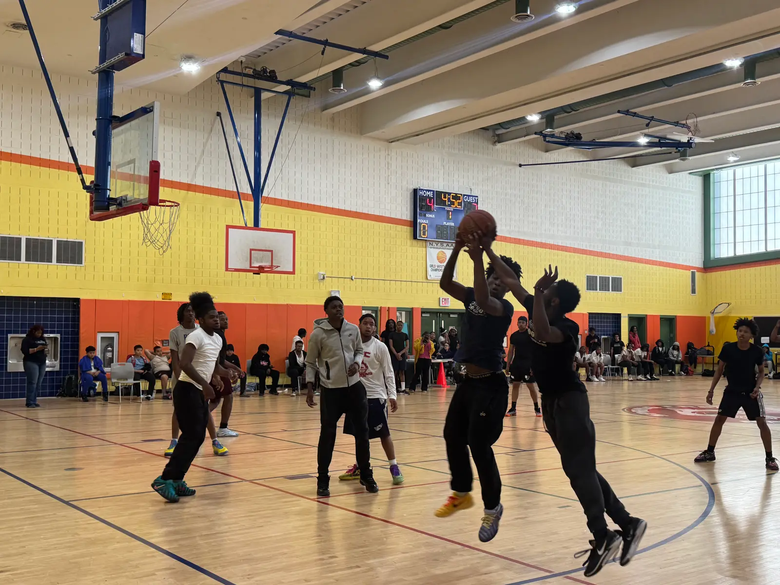Students competing in an indoor school basketball game