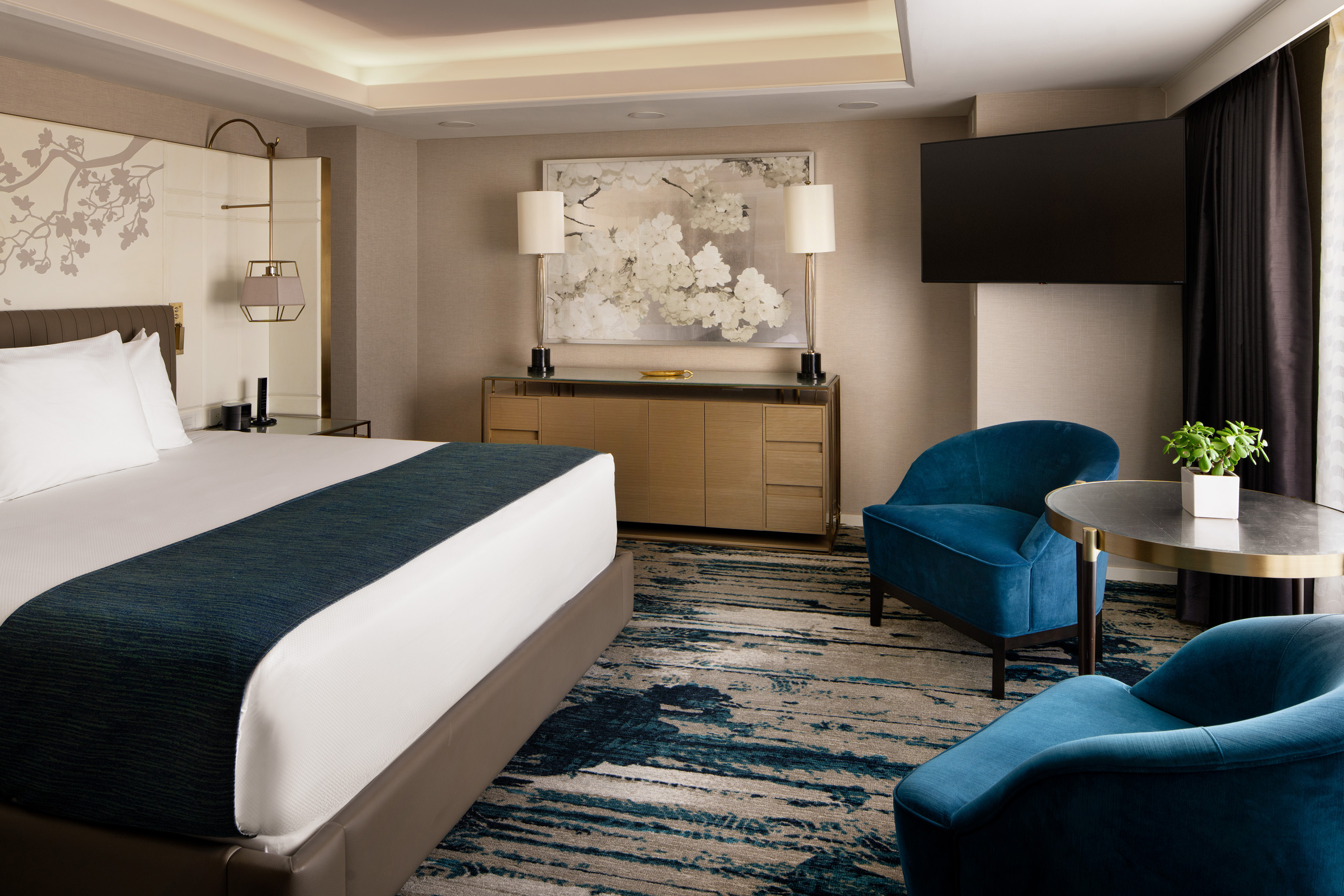 Executive suite bedroom with king bed and blue chairs.