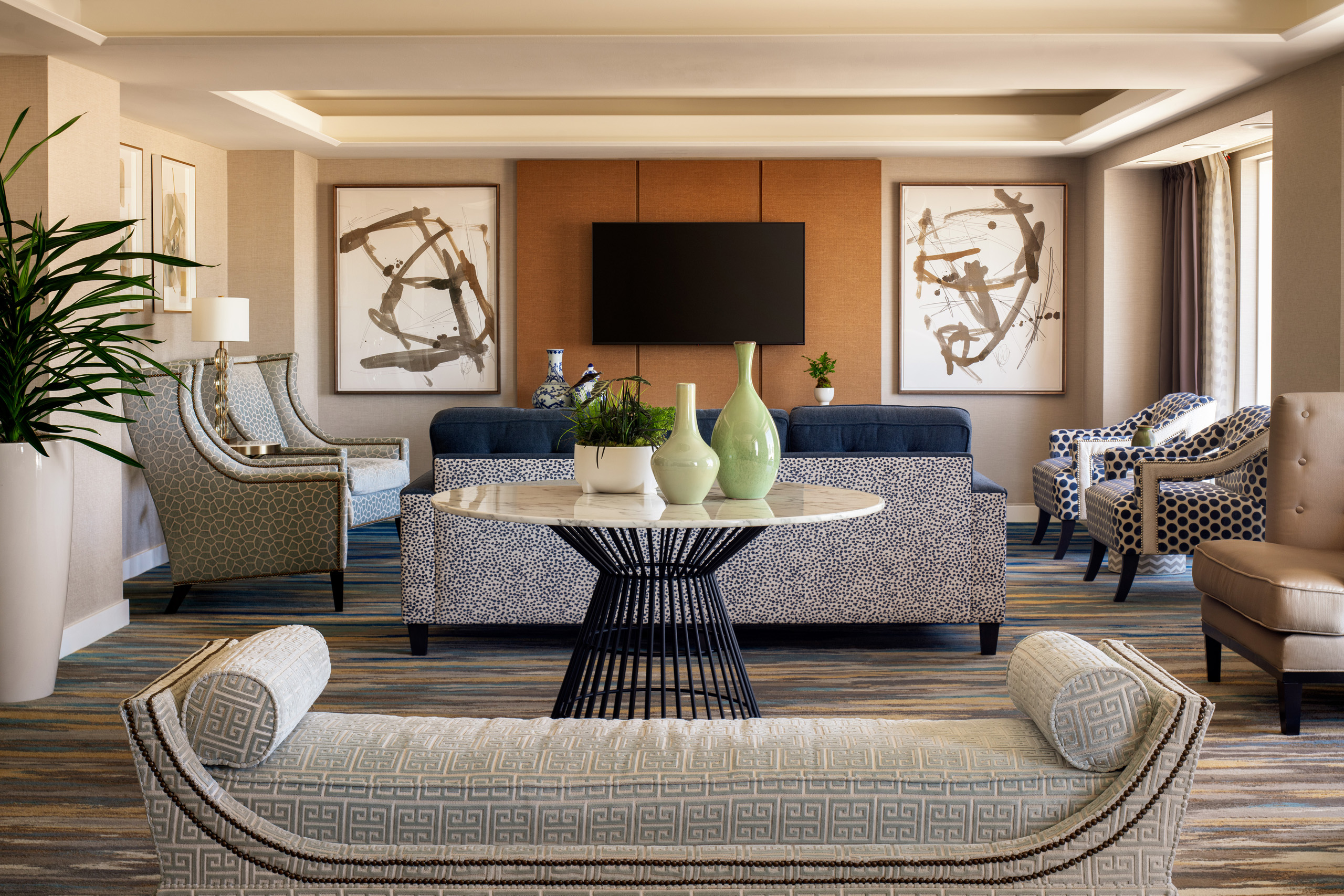 Imperial suite living room with sofas, chairs, and television.