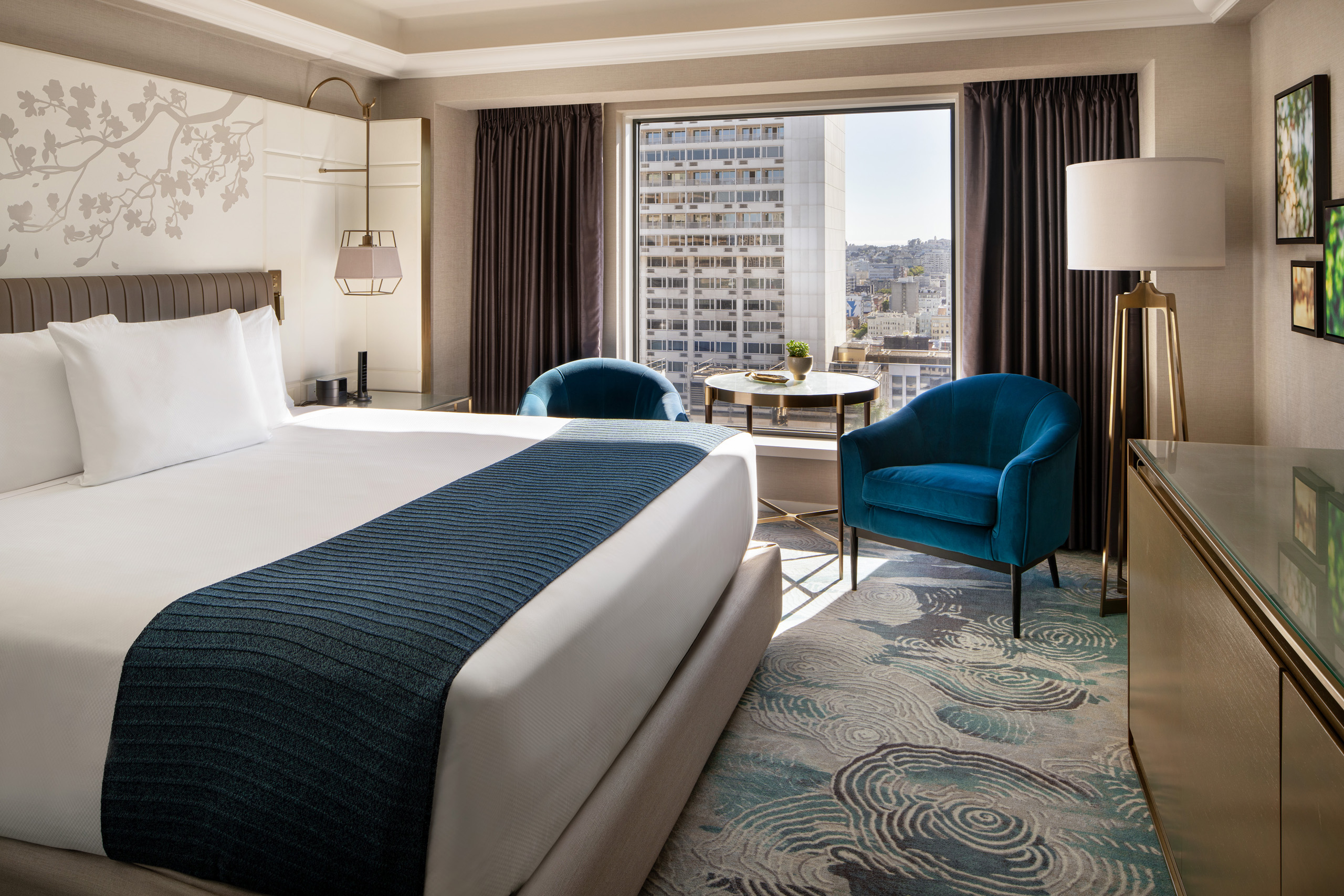 Imperial king room with city skyline and patterned sofa.