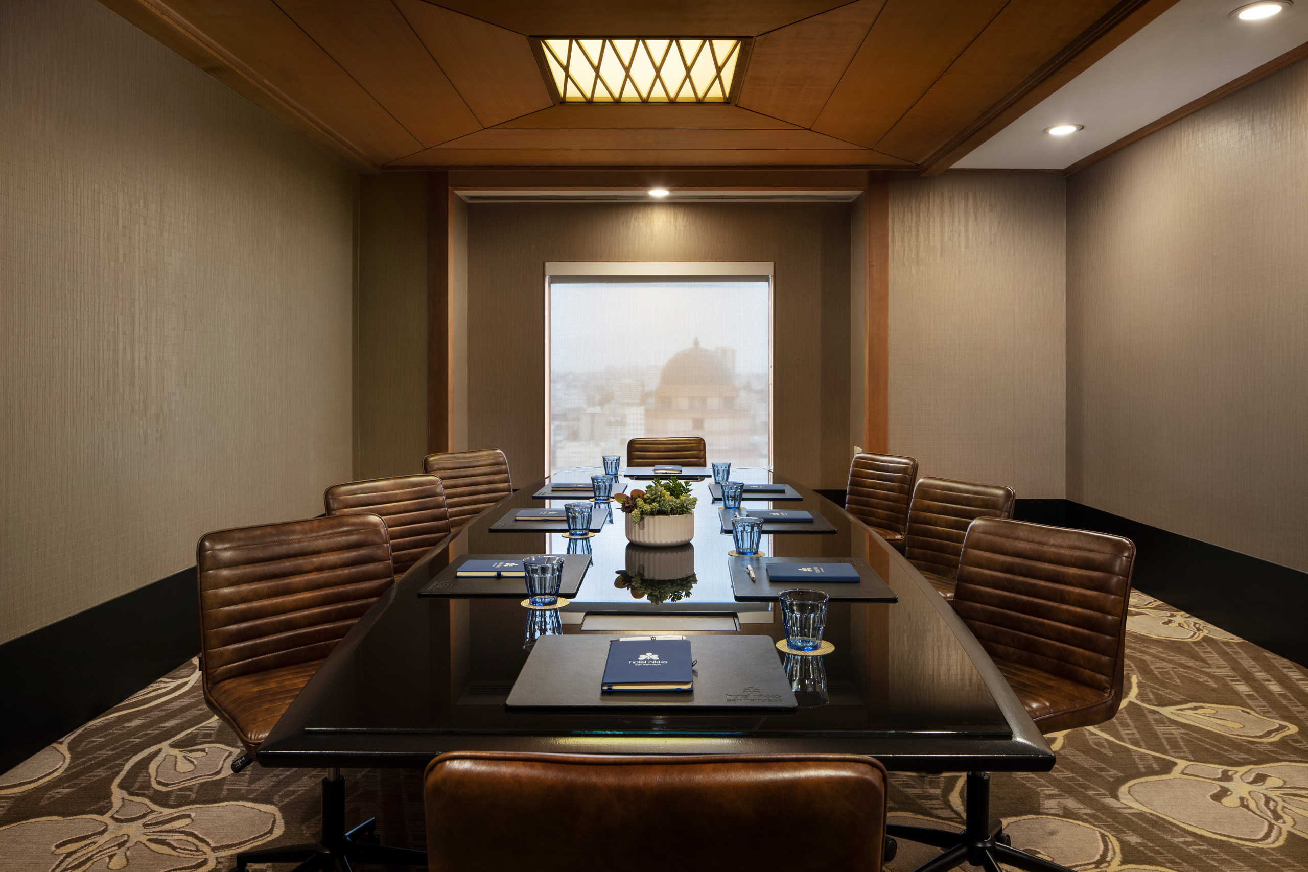 Boardroom with leather chairs and city view.
