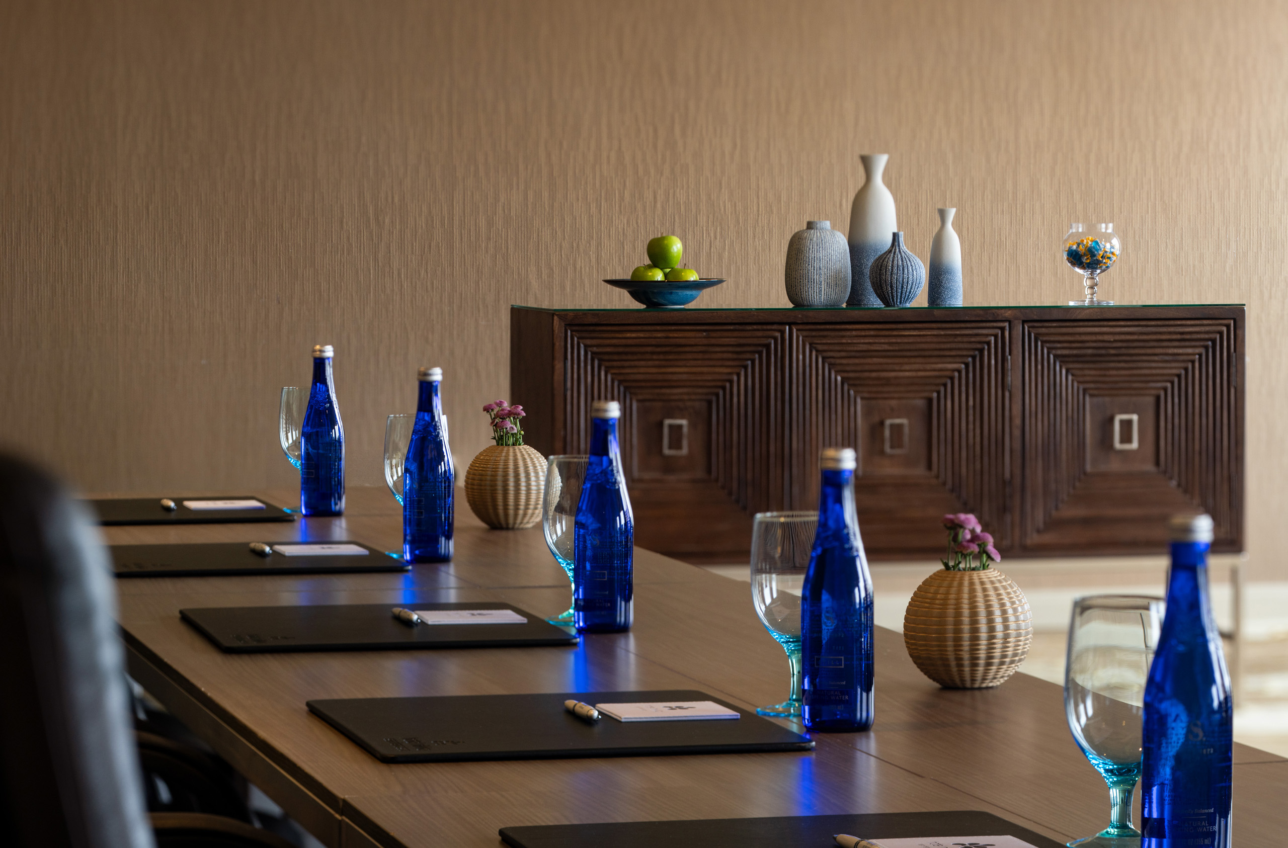 Boardroom table with water bottles and meeting materials