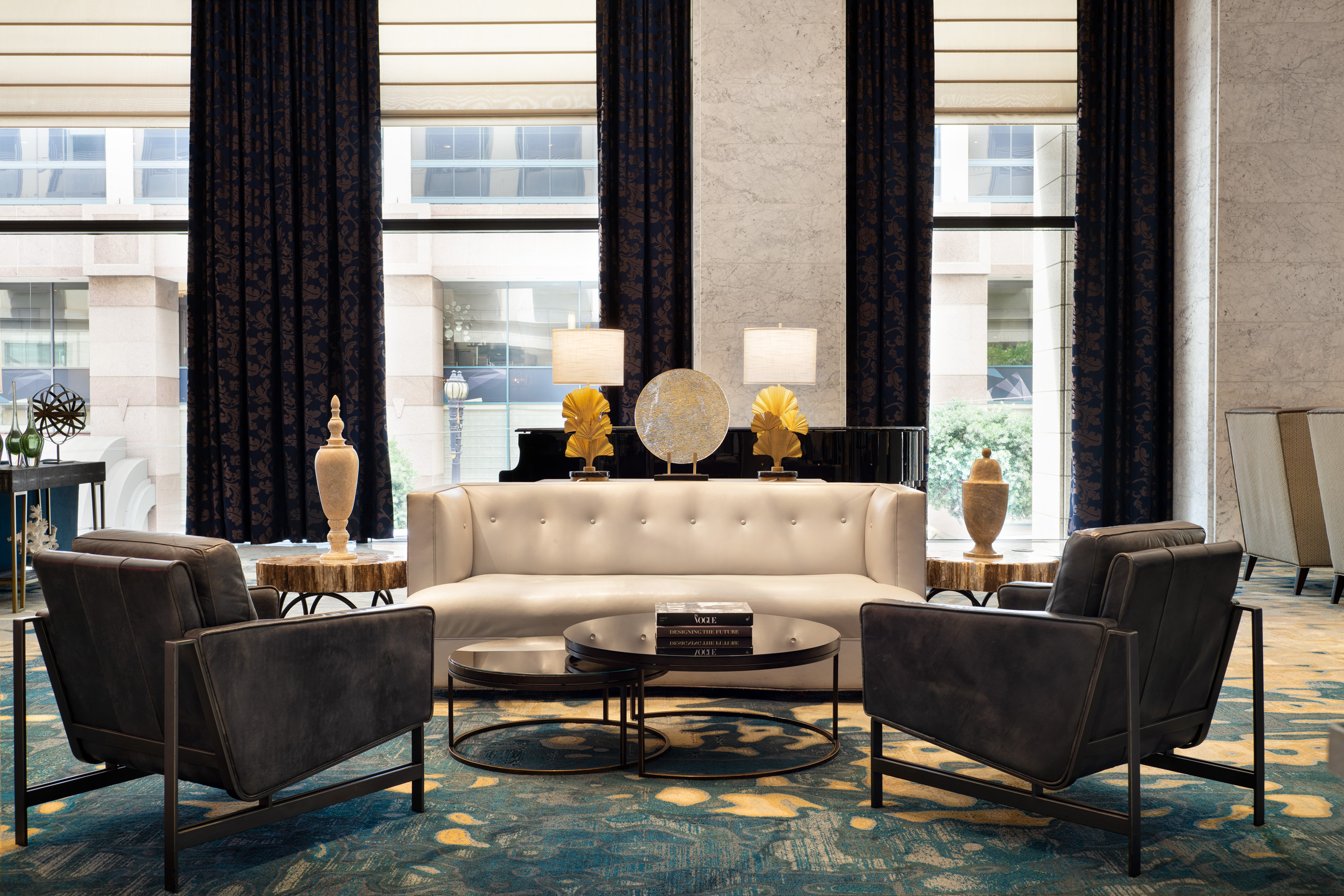 Modern hotel lobby seating with white sofa and black lounge chairs.