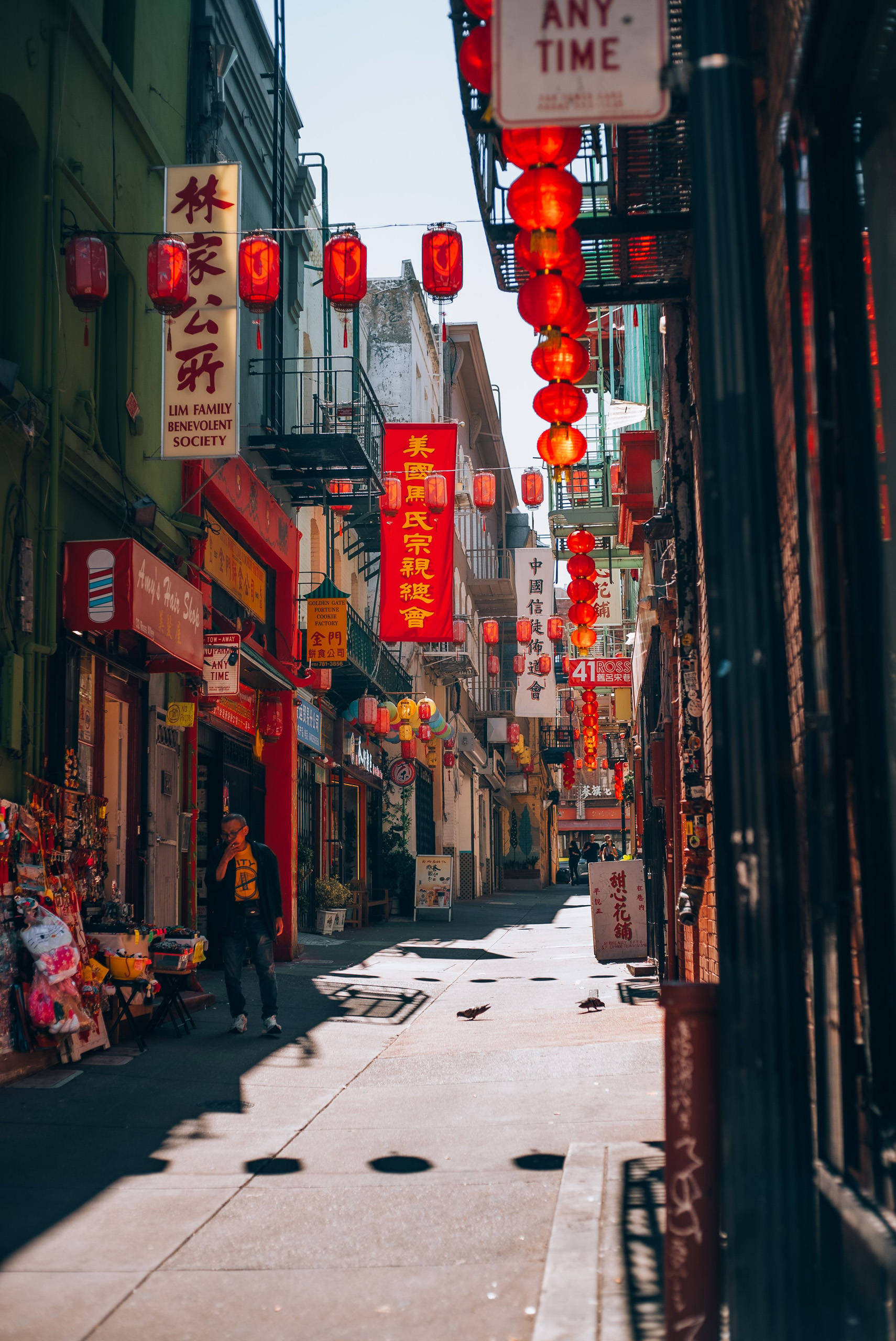 Chinatown street lined with red lanterns and storefront signs.
