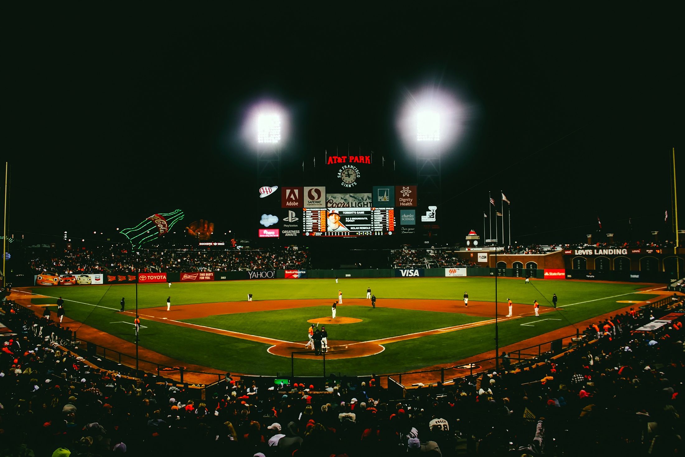 Baseball game under stadium lights at San Francisco ballpark.