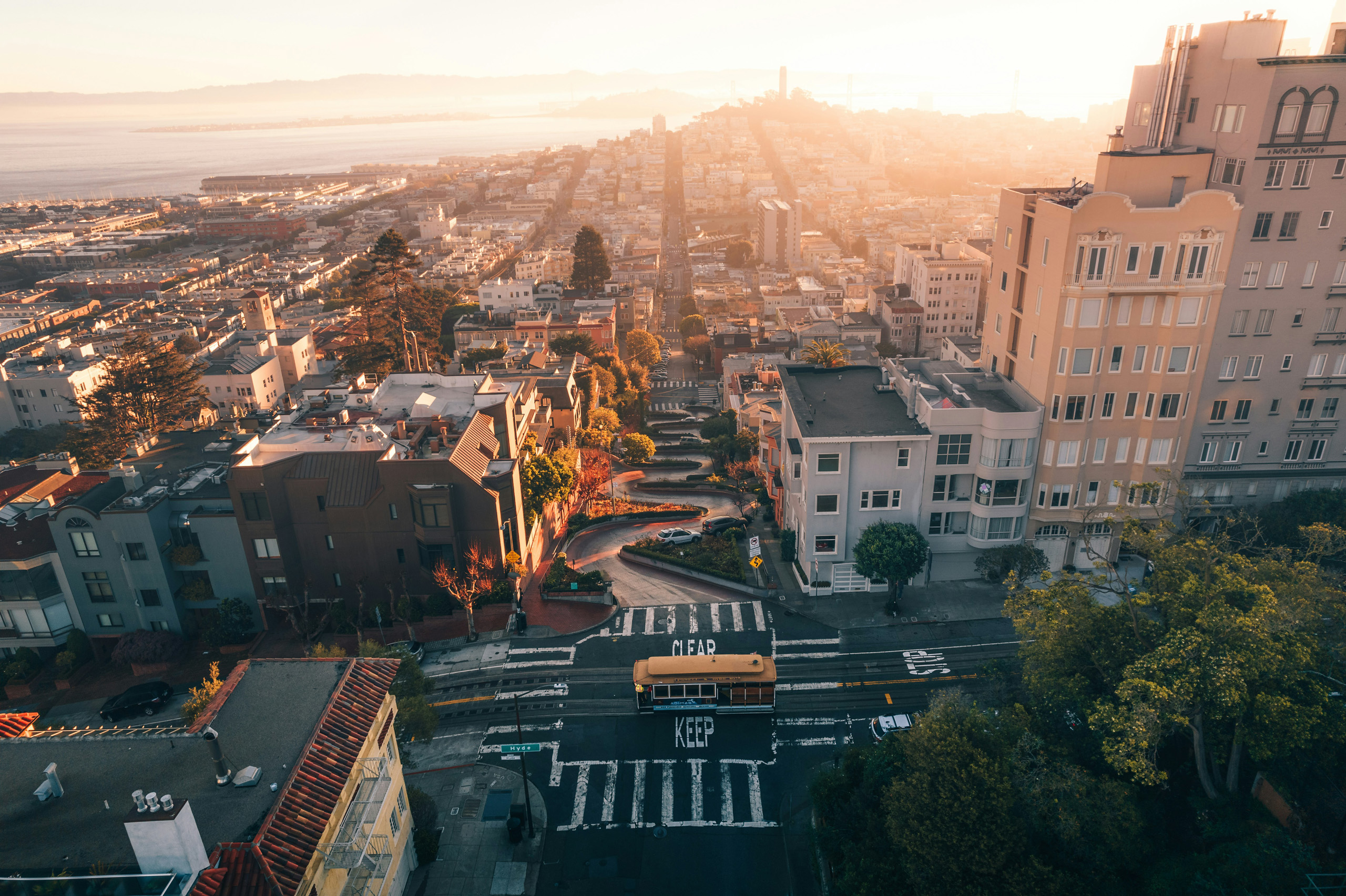 Lombard Street winding downhill through San Francisco at sunset.