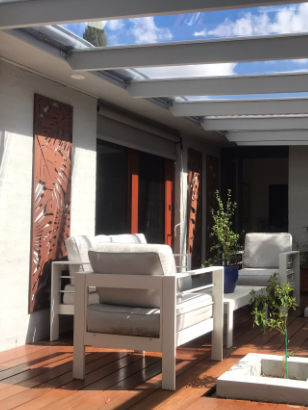 Polycarbonate patio roofing over a timber deck with outdoor lounge seating