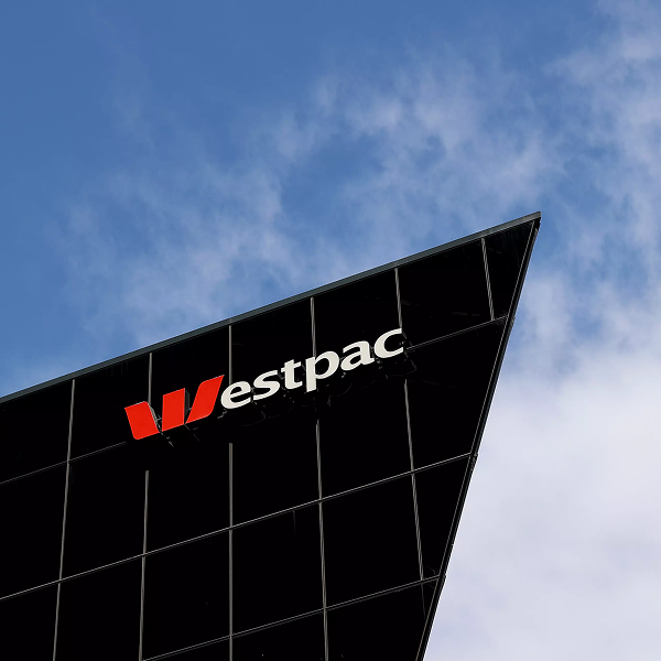 Westpac logo on the corner of a dark glass office tower against a blue sky