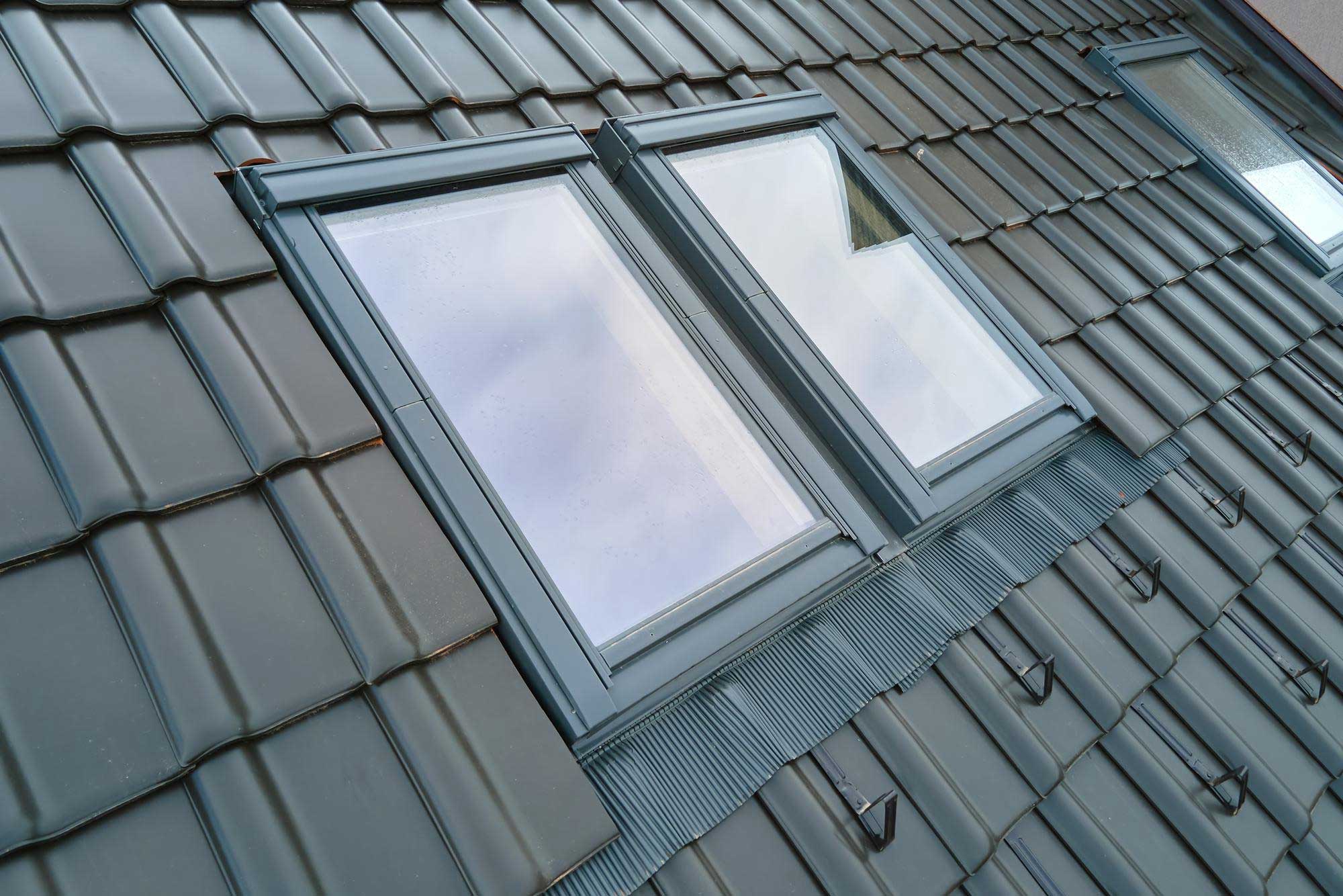 Two skylights installed side by side in a grey tiled roof