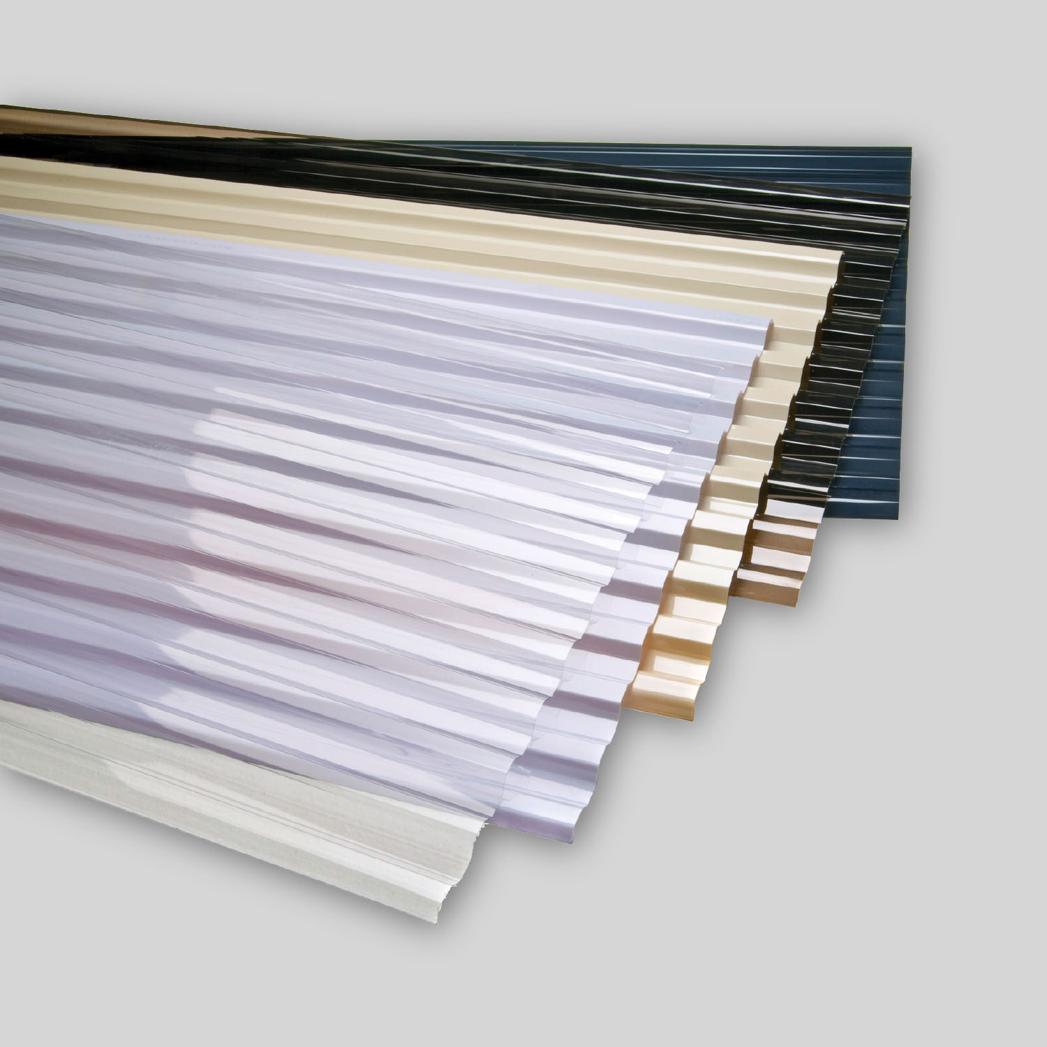 Corrugated polycarbonate roofing sheets fanned out in clear, opal, cream, grey and dark blue