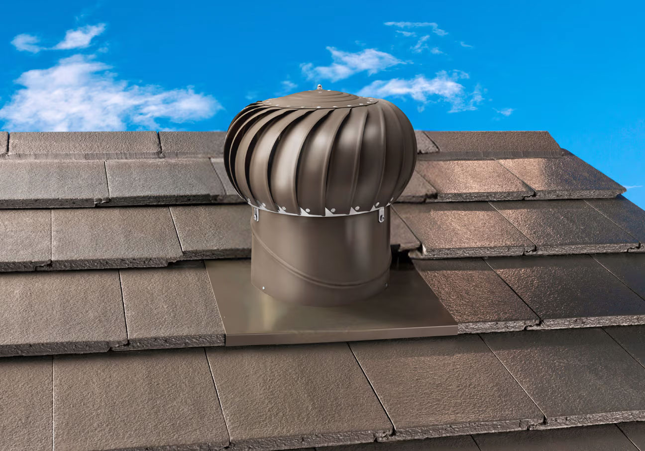 Whirlybird rotary roof ventilator installed on a tiled roof against a blue sky