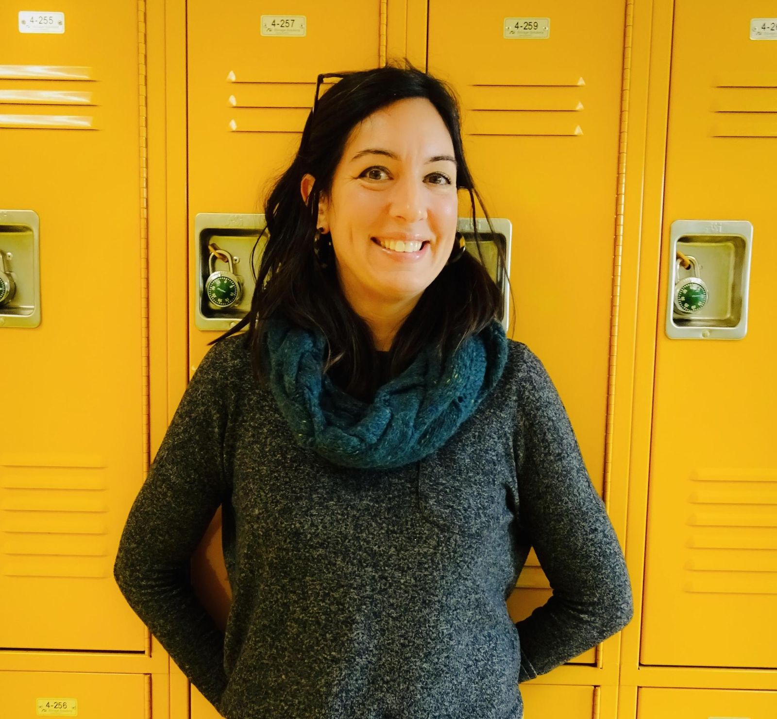 Lucia Brockway standing by yellow numbered hallway lockers
