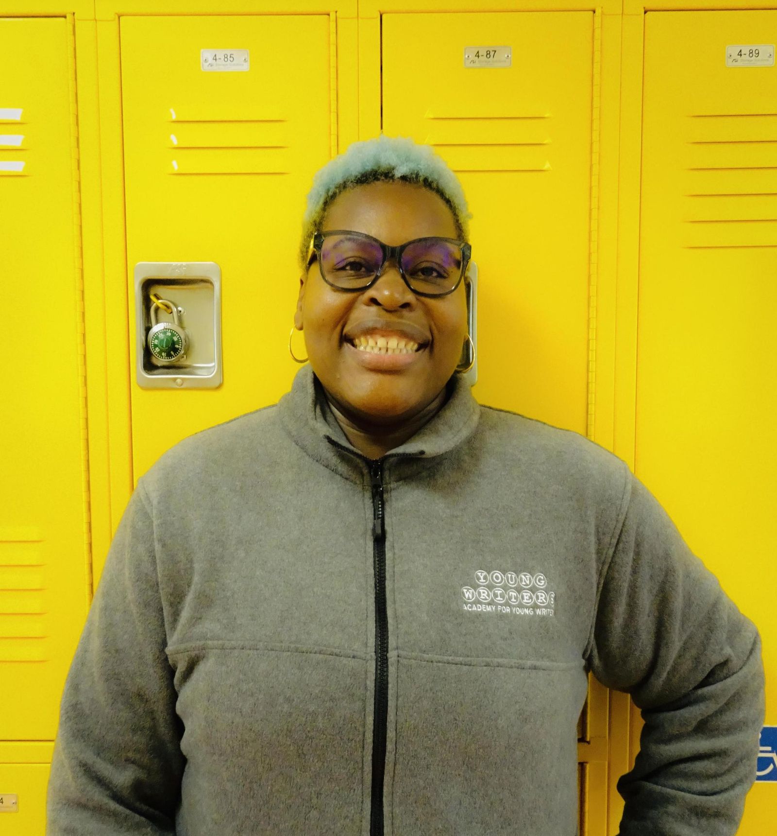 Sherlie Jean-Gilles wearing Young Writers Academy jacket by lockers
