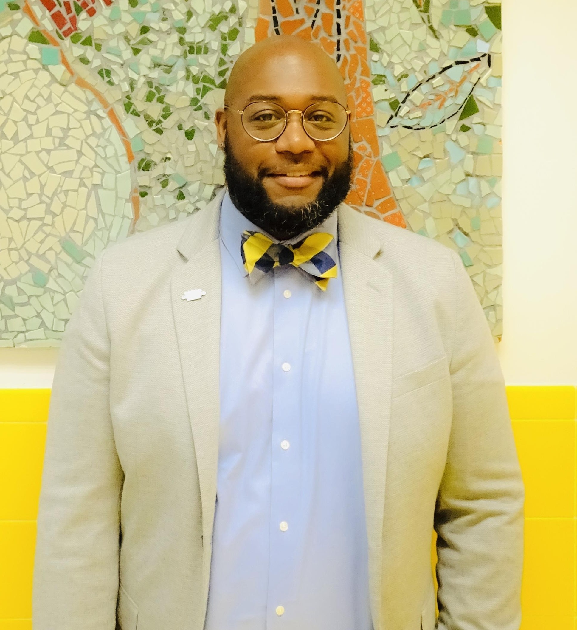 Keith Bailey smiling in blazer and bow tie at school